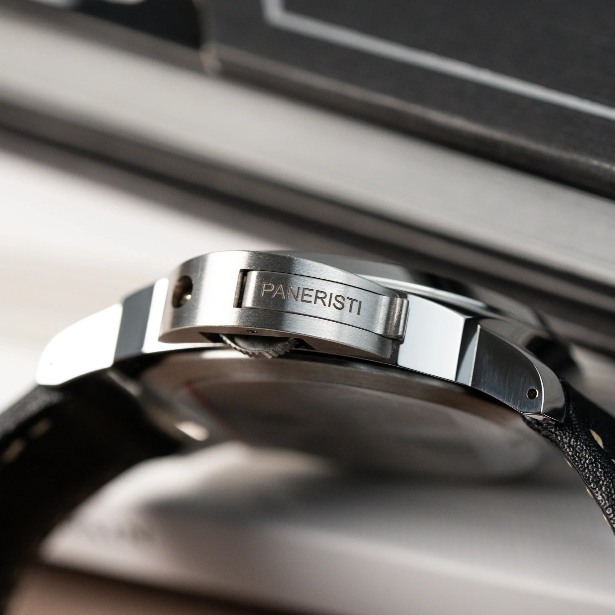 Seitlicher Blick auf den Kronenschutz der Panerai Luminor Logo Base mit dem "Paneristi" Schriftzug auf dem Kronenschutz