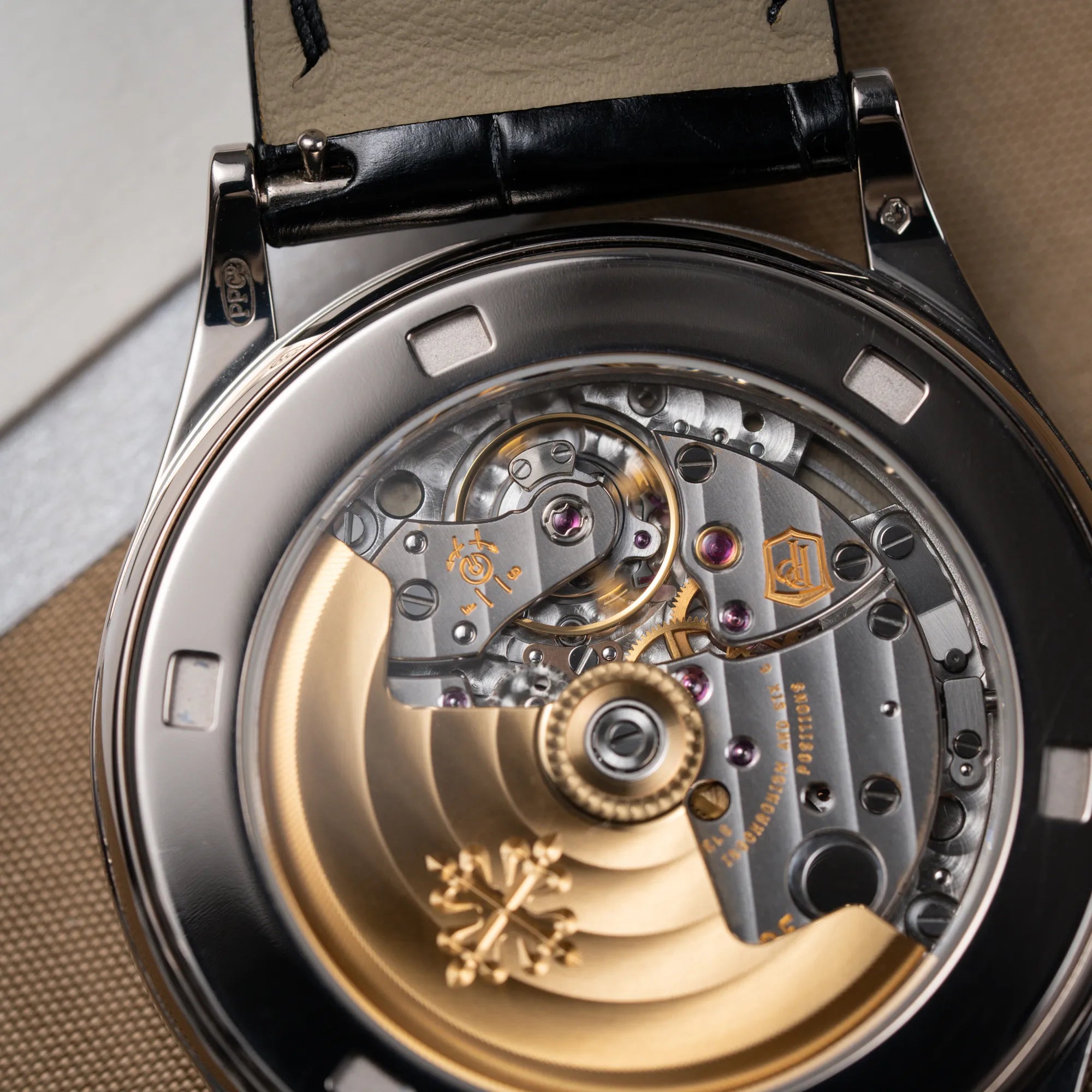 Detailaufnahme des Uhrwerks mit goldenem Rotor durch den Sichtboden von der Patek Philippe Calatrava 5269G in Weißgold mit weißem Sector-Dial