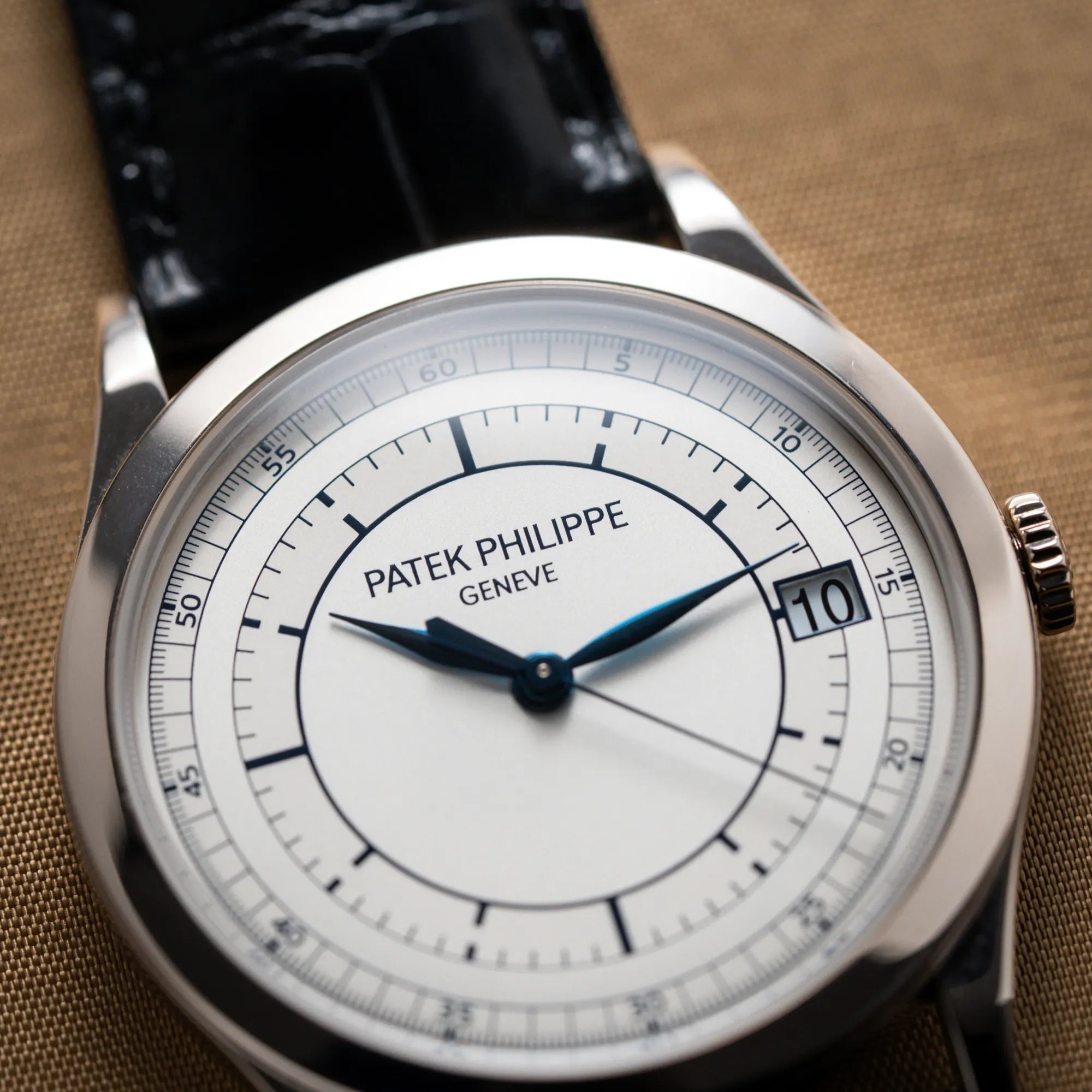 Detailaufnahme der Patek Philippe Calatrava 5269G in Weißgold mit weißem Sector-Dial mit Fokus auf dem "Patek Philiippe Geneve" Schriftzug auf dem Zifferblatt