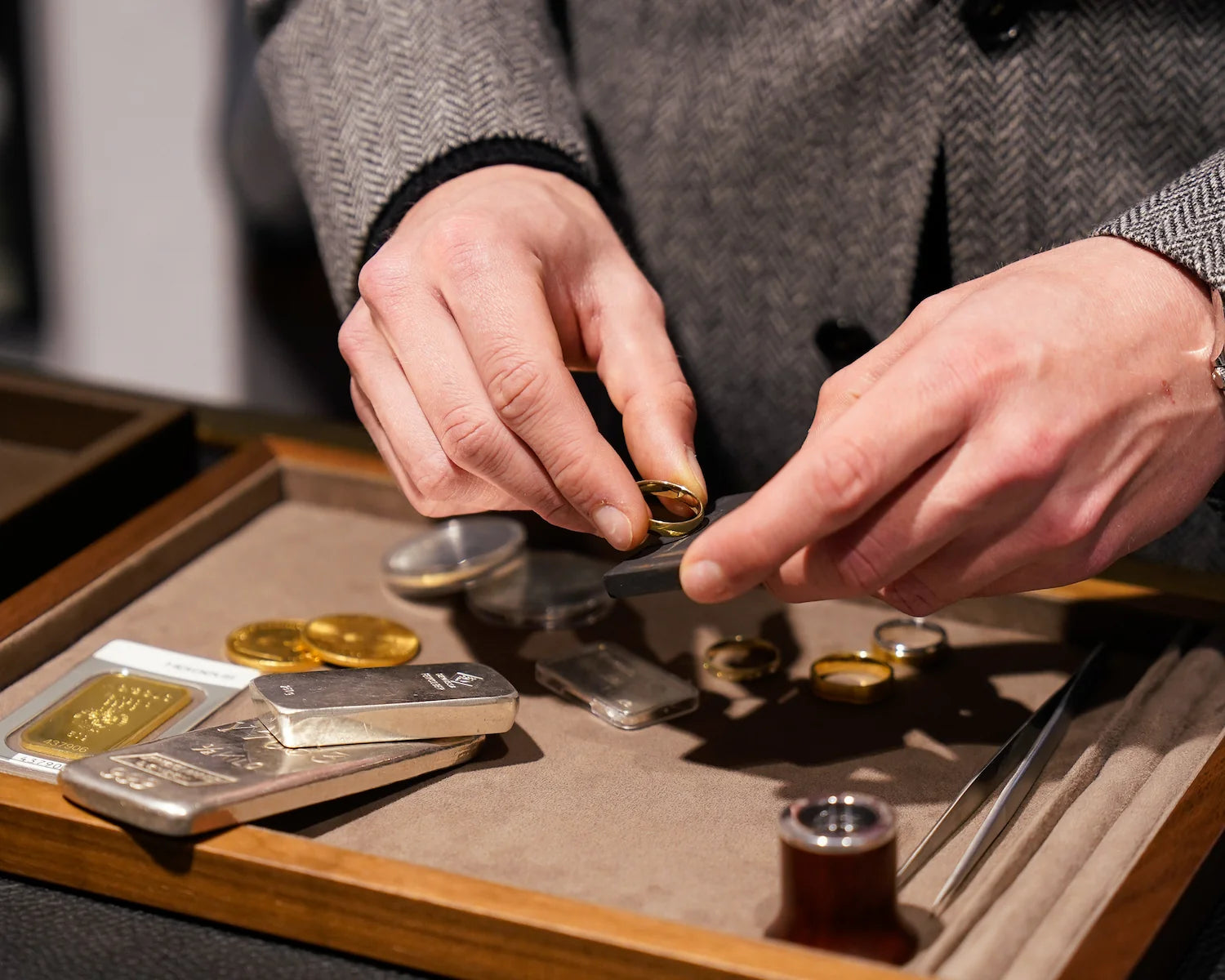 Prüfen eines Goldrings auf dessen Legierung mit einem Prüfstein während eines Gold- & Schmuckankaufs bei Schmuckatelier Lang