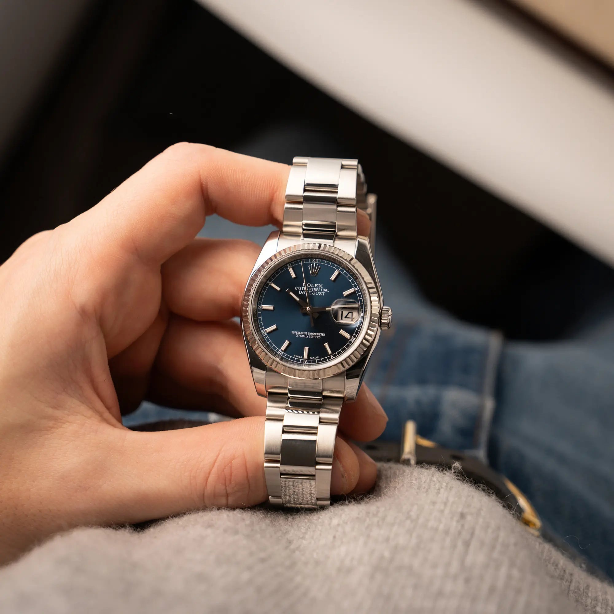 Mann hält die Rolex Datejust 36 der Referenz 116234 mit geriffelter Lünette und blauem Sonnenschliff-Zifferblatt