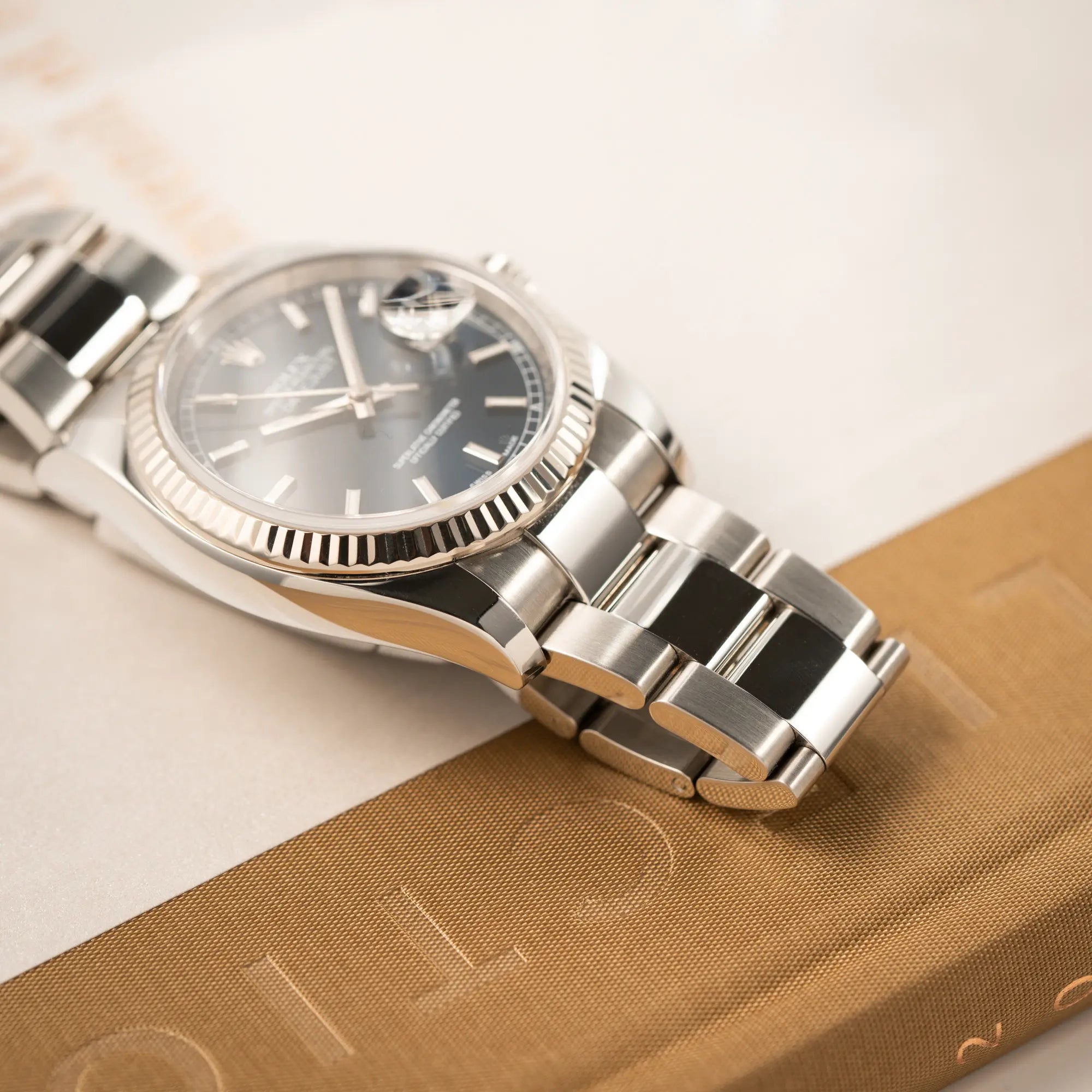Produkfotografie der Rolex Datejust 36 der Referenz 116234 mit geriffelter Lünette und blauem Sonnenschliff-Zifferblatt zeigt die Bandanstöße und den Zustand des Oyster-Stahlbands