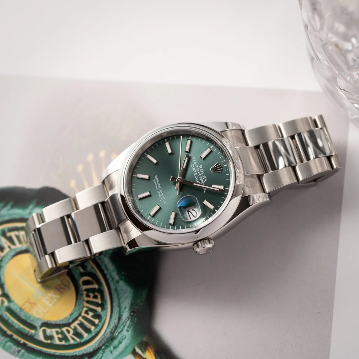 Produktfotografie der mit Stickern teil-verklebte Rolex Datejust 36 der Referenz 126200 mit glatter Lünette am Oyster-Stahlband mit dem Mint-Green-Zifferblatt