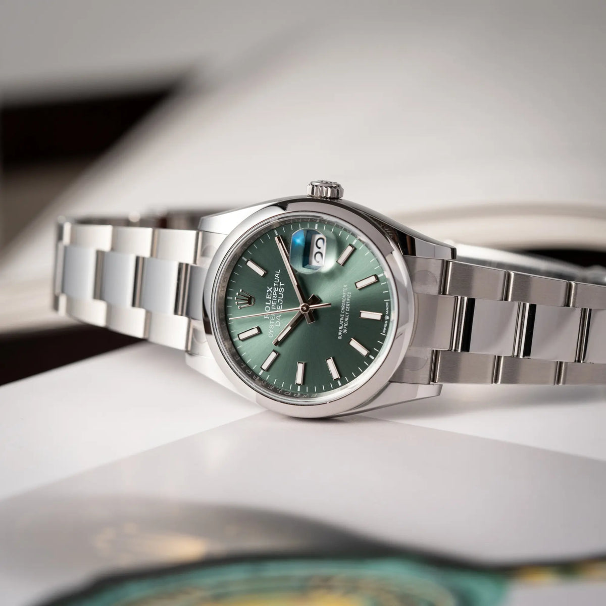 Produktfotografie als Titelbild von der mit Stickern teil-verklebte Rolex Datejust 36 der Referenz 126200 mit glatter Lünette am Oyster-Stahlband mit dem Mint-Green-Zifferblatt