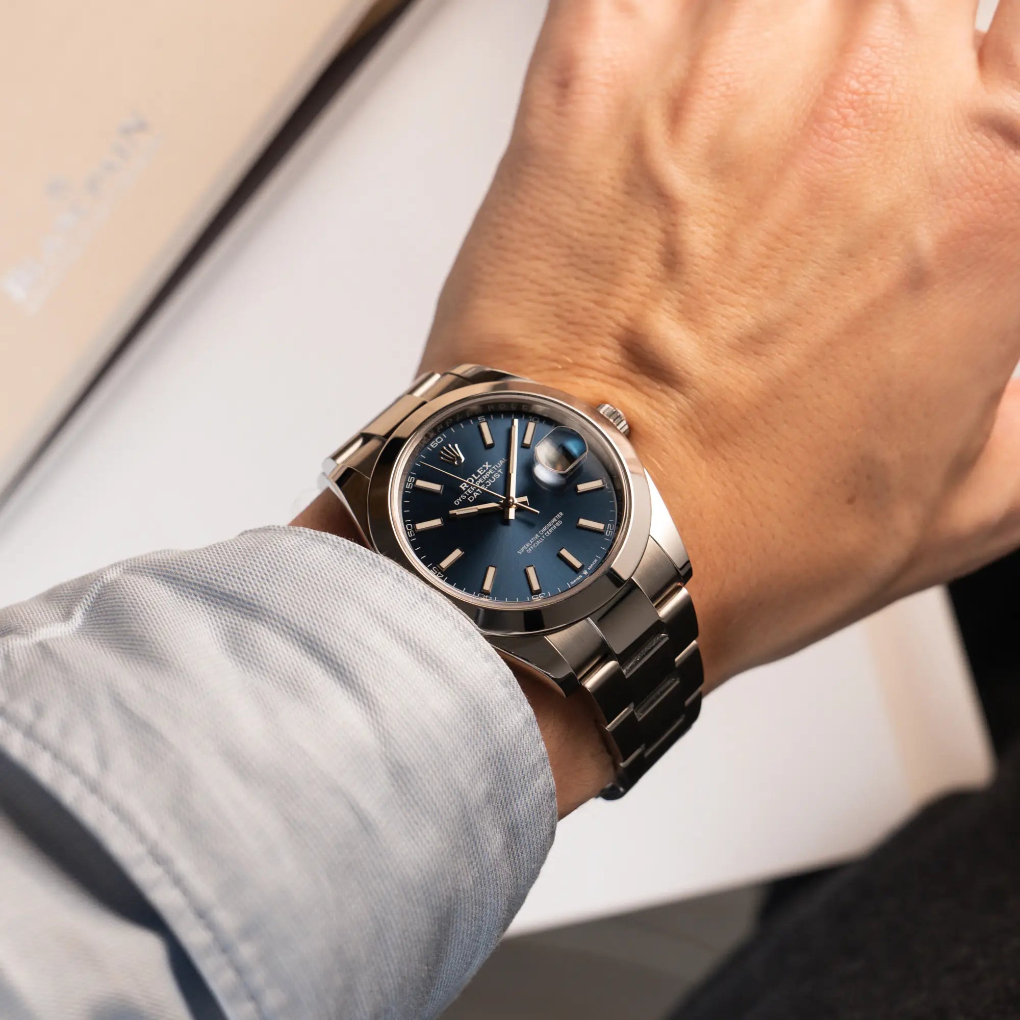 Mann trägt die Rolex Datejust 41 der Referenz 126300 mit blauem Zifferblatt, glatter Lünette, am Oyster-Stahlband für einen Wristshot an seinem Handgelenk