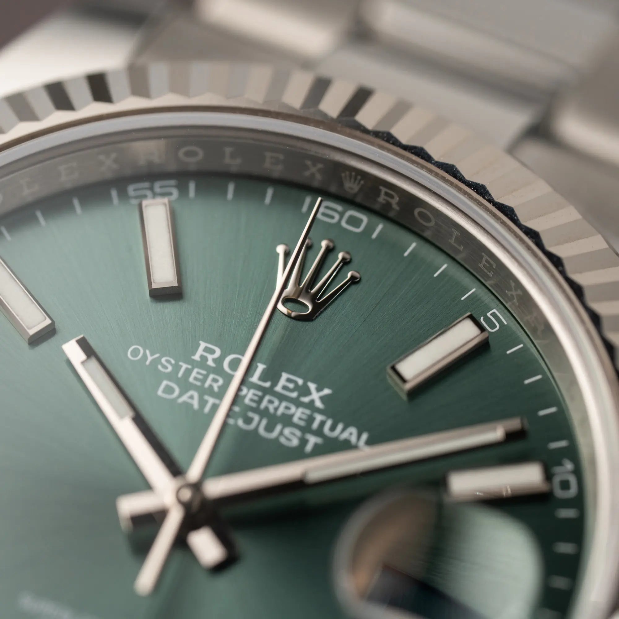 Makroaufnahme Rolex Datejust 41 der Referenz 126334 mit dem grünem Zifferblatt am Oyster-Stahlband mit Fokus auf der Rolex Rehaut bei 12 Uhr