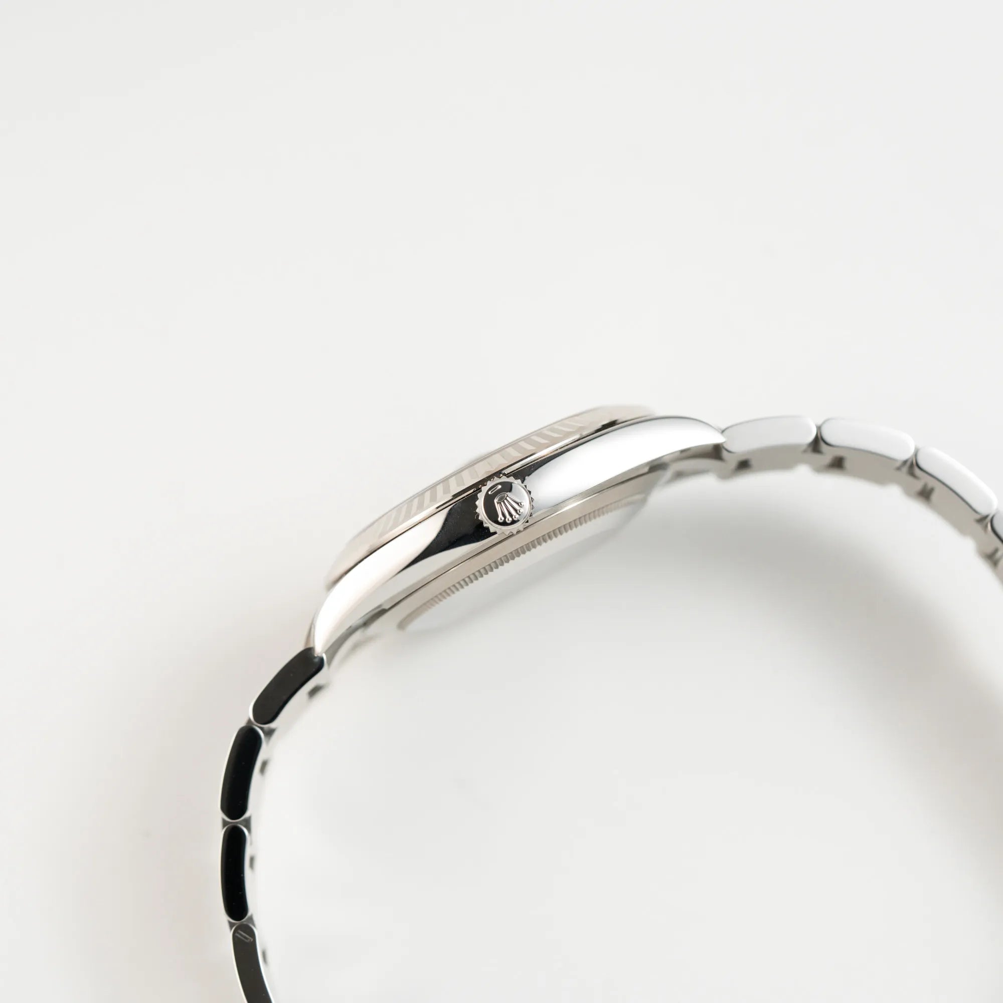 Seitliche Gehäuseflanke der Rolex Datejust 41 der Referenz 126334 mit dem grünem Zifferblatt am Oyster-Stahlband mit Blick auf die Auzugskrone