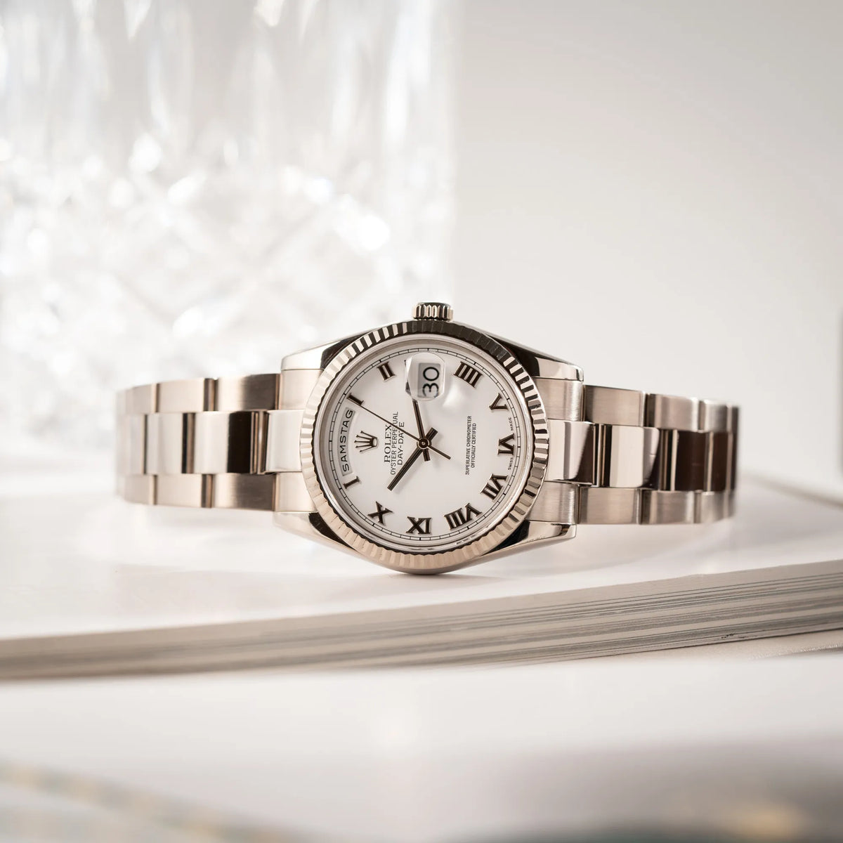 Produktfotografie der Rolex Day-Date 36 Armbanduhr in Weißgold der Referenz 118239 mit weißem Zifferblatt mit römischen Indizes am Oyster-Weißgold-Armband