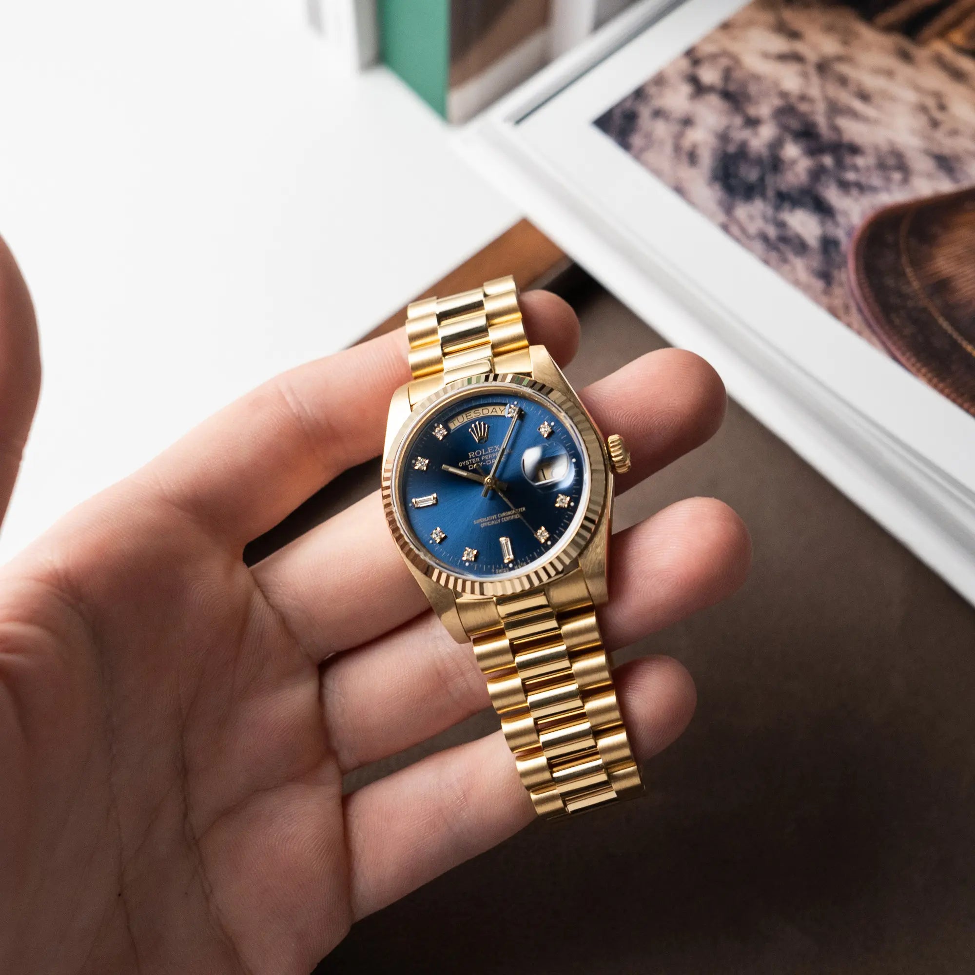 Mann hält die Rolex Day-Date 36 (Referenz: 18038) in Gelbgold mit blauem Diamant-Zifferblatt in seiner Hand