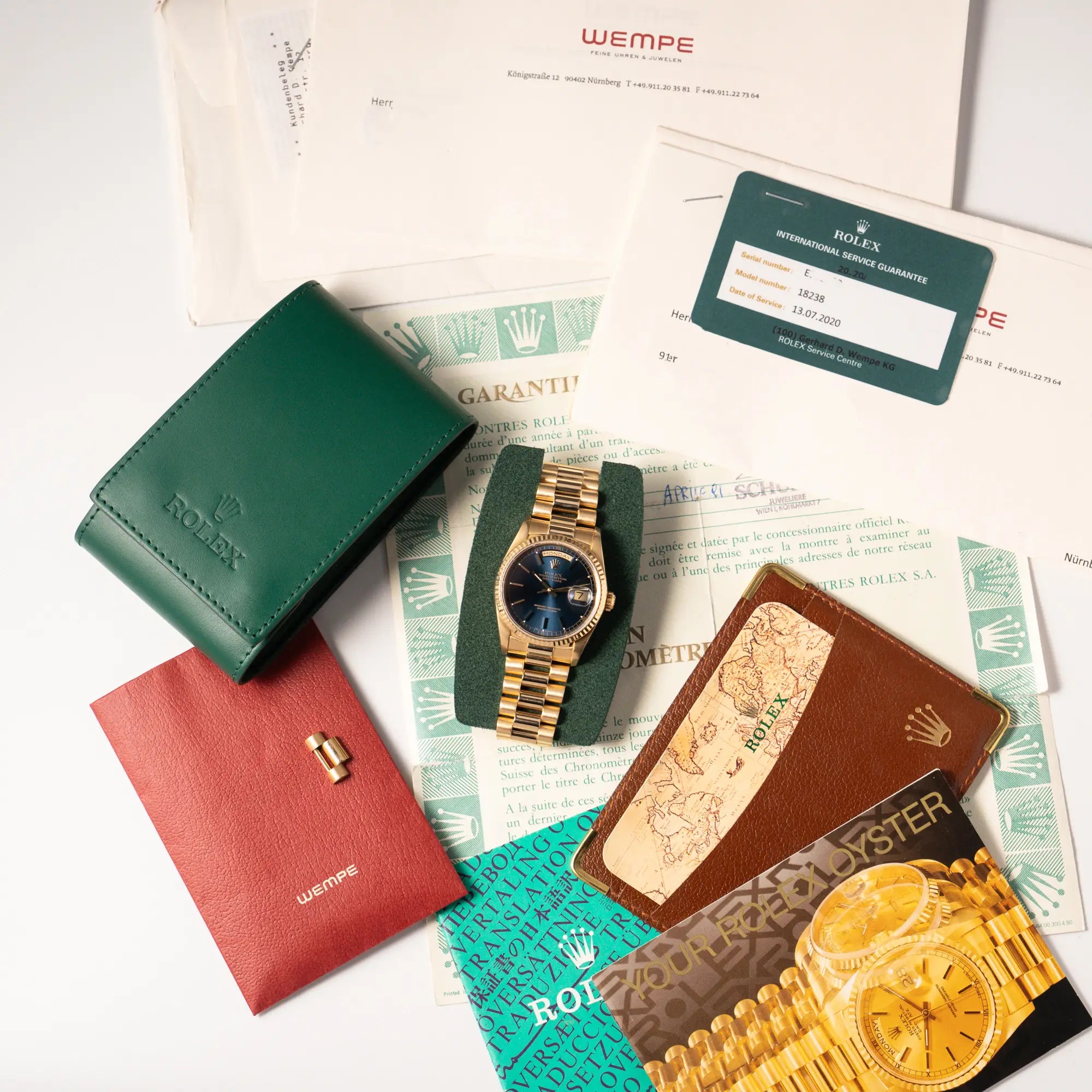 Lieferumfang zugehörig zu der der gelbgoldenen Rolex Day-Date 36 der Referenz 18238 mit blauem Zifferblatt und englisch-sprachiger Tagesanzeige, bestehend aus Travel-Box, Papieren, Booklets und Wempe-Servicebeleg