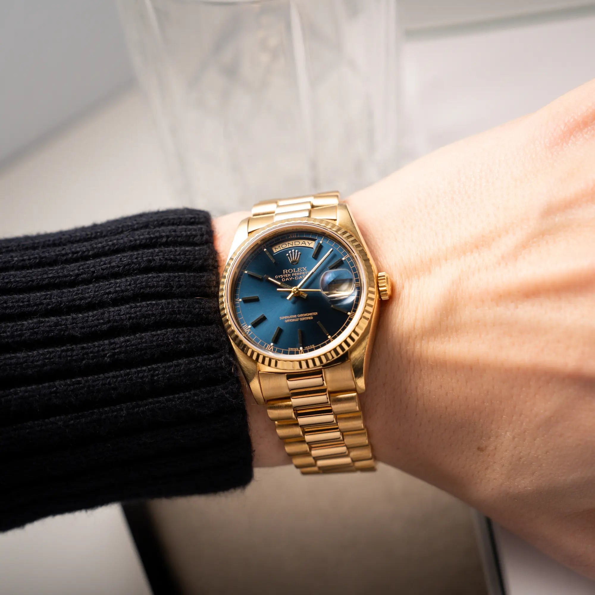 Wristshot mit der gelbgoldenen Rolex Day-Date 36 der Referenz 18238 mit blauem Zifferblatt und englisch-sprachiger Tagesanzeige