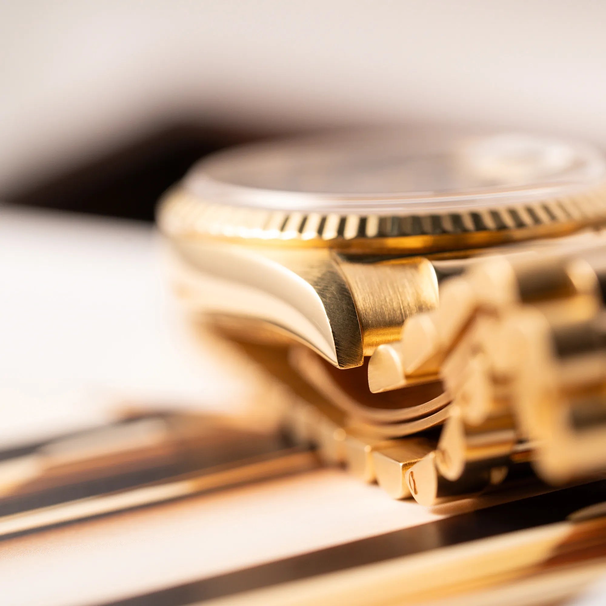Detailaufnahme des Bandanstoßes mit erkennbarer Streuktur des Edelmetalls der gelbgoldenen Rolex Day-Date 36 der Referenz 18238 mit blauem Zifferblatt und englisch-sprachiger Tagesanzeige