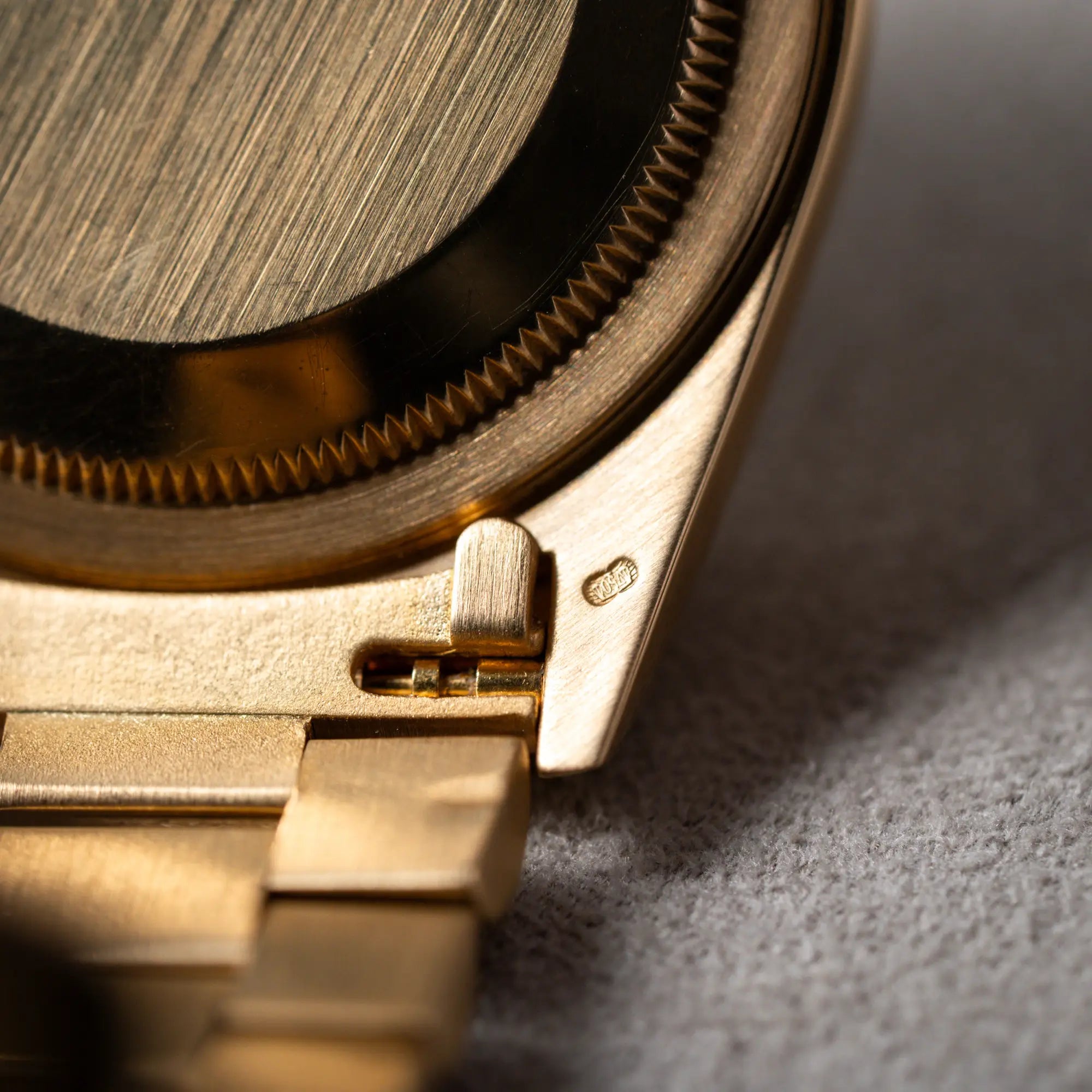 Detailaufnahme des Bandanstoßes von unten mit Blick auf den Federsteg der gelbgoldenen Rolex Day-Date 36 der Referenz 18238 mit blauem Zifferblatt und englisch-sprachiger Tagesanzeige