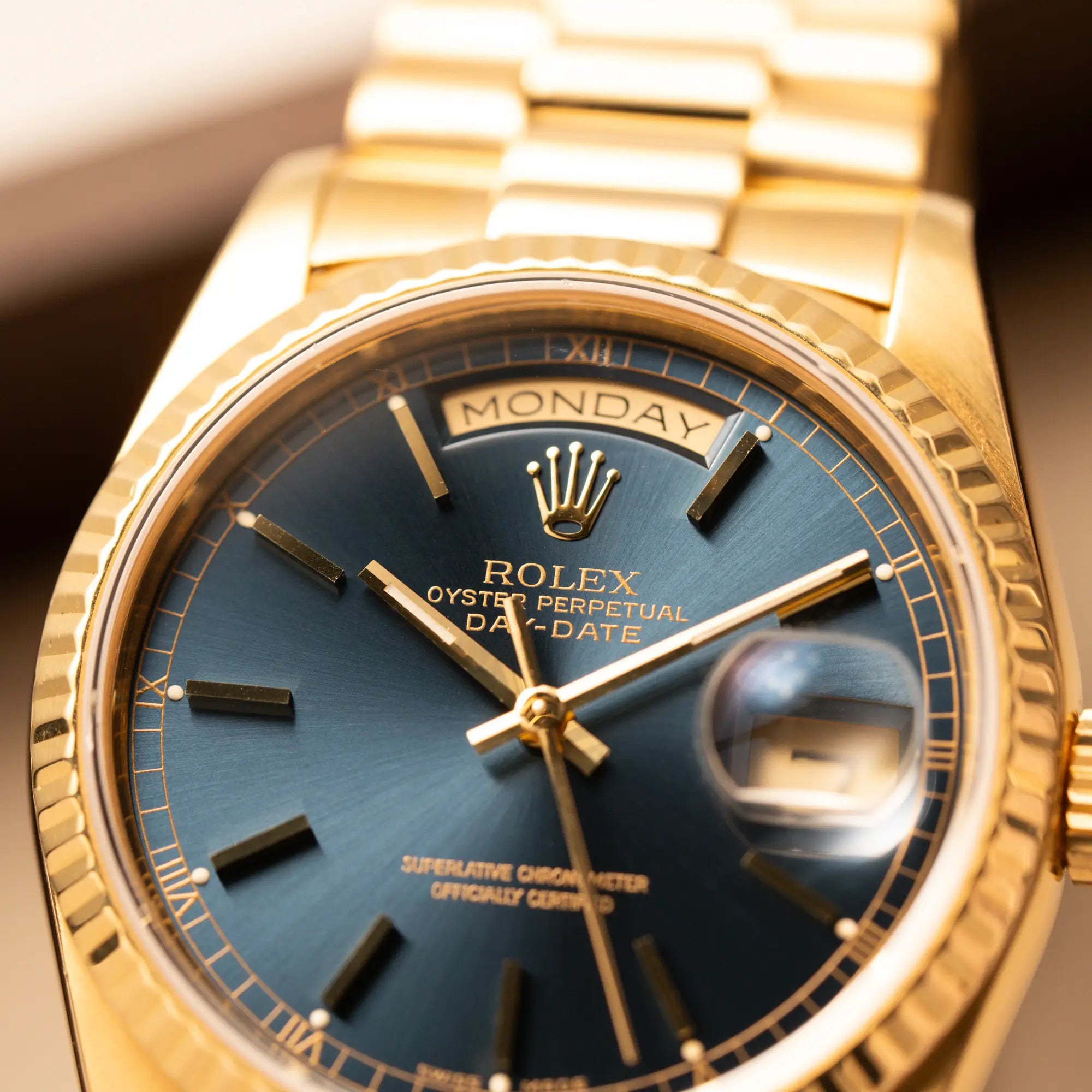 Detailaufnahme der gelbgoldenen Rolex Day-Date 36 der Referenz 18238 mit blauem Zifferblatt und englisch-sprachiger Tagesanzeige