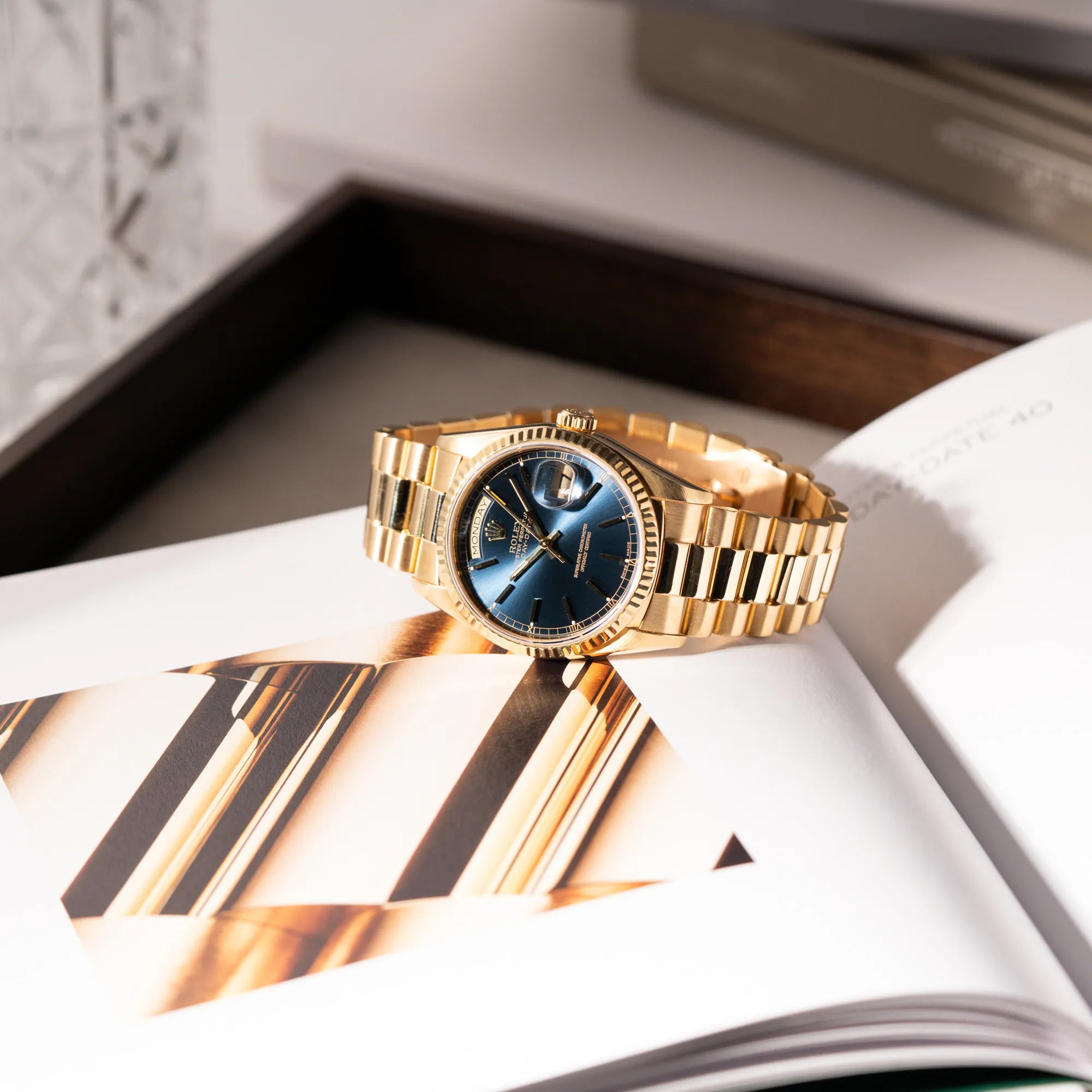 Produktfotografie der gelbgoldenen Rolex Day-Date 36 der Referenz 18238 mit blauem Zifferblatt und englisch-sprachiger Tagesanzeige