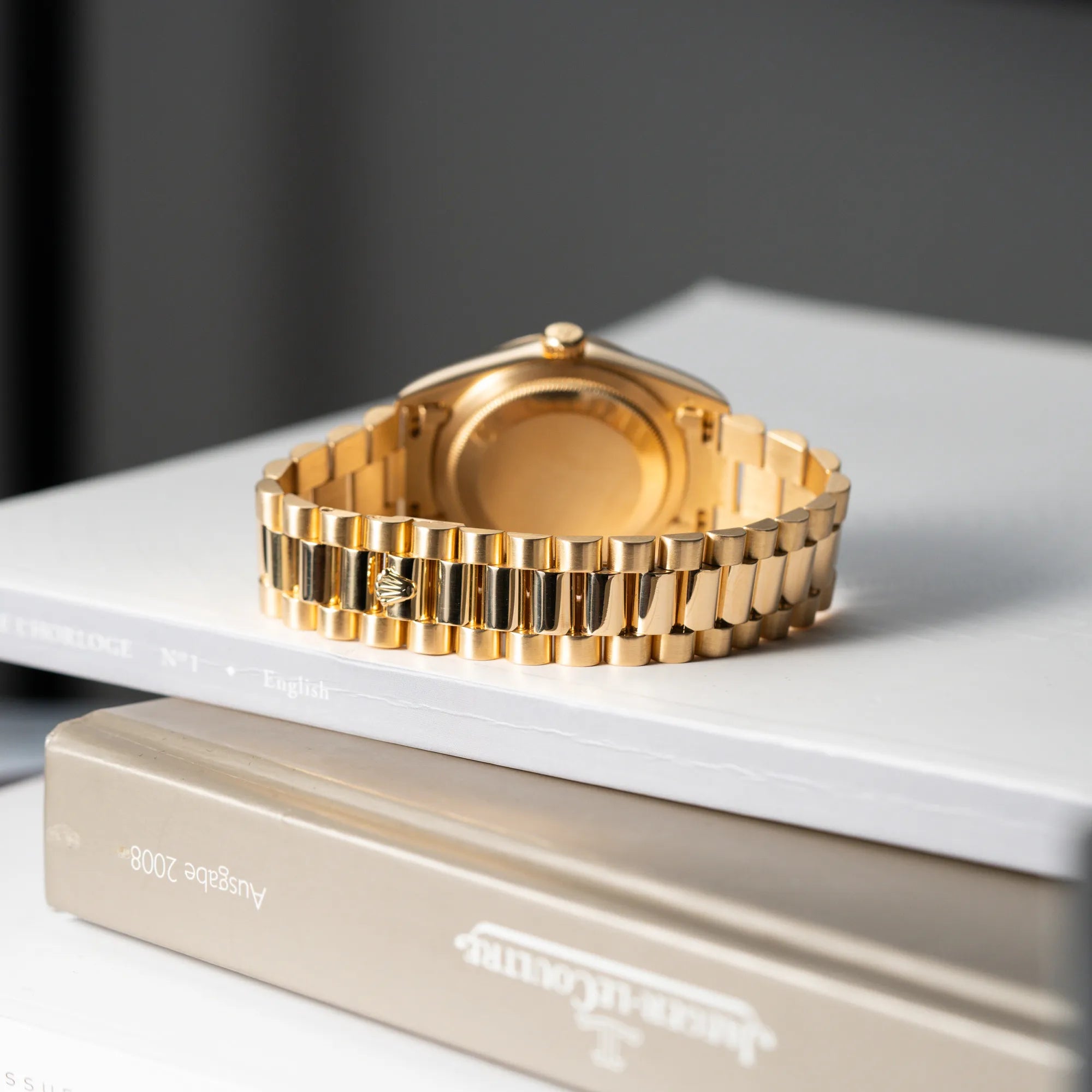Produktfotografie der gelbgoldenen Rolex Day-Date 36 der Referenz 18238 mit blauem Zifferblatt und englisch-sprachiger Tagesanzeige mit Fokus auf dem President-Armband