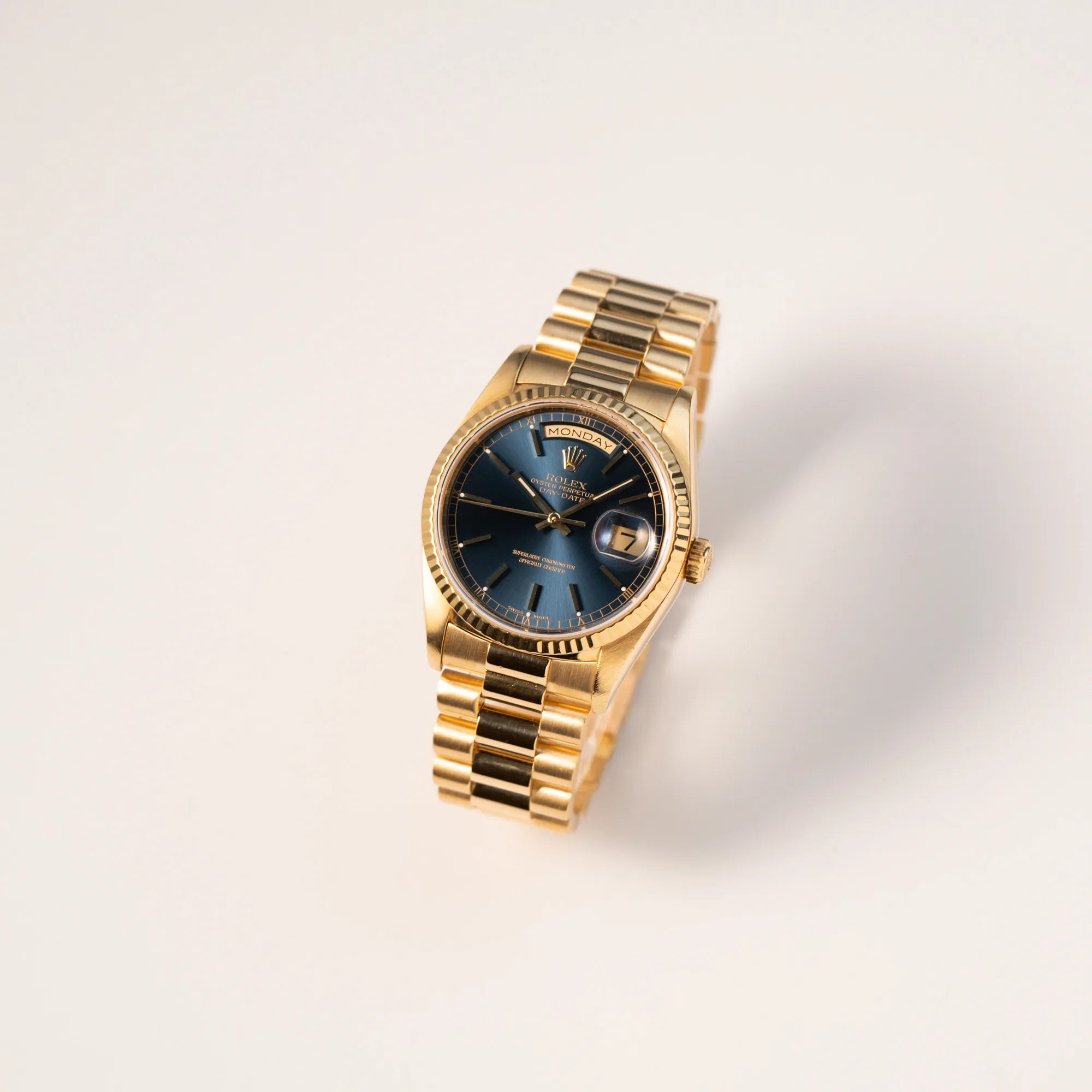 Leicht seitliche Ansicht der gelbgoldenen Rolex Day-Date 36 der Referenz 18238 mit blauem Zifferblatt und englisch-sprachiger Tagesanzeige
