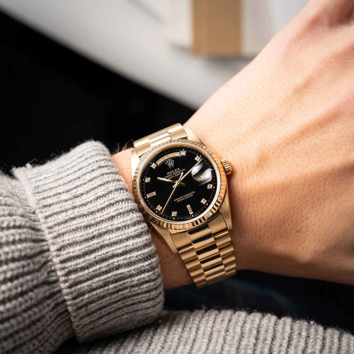 Mann trägt die Rolex Day-Date 36 der Referenz 18238 in Gelbgold mit schwarzen Diamond-Dial am President-Armband an seinem Handgelenk