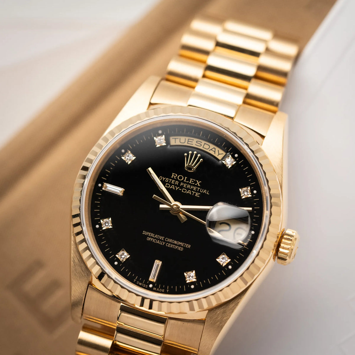 Detailaufnahme der Rolex Day-Date 36 der Referenz 18238 in Gelbgold mit schwarzen Diamond-Dial am President-Armband