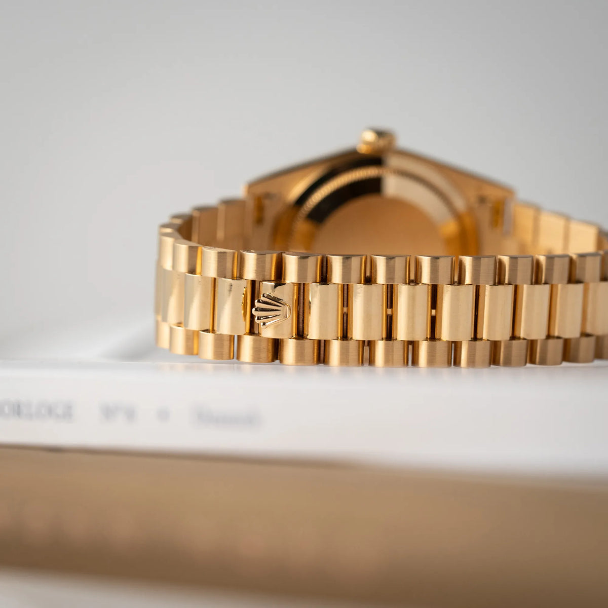 Detailaufnahme zeigt die Rolex-Krone auf dem President-Armband der Rolex Day-Date 36 der Referenz 18238 in Gelbgold mit schwarzen Diamond-Dial am President-Armband