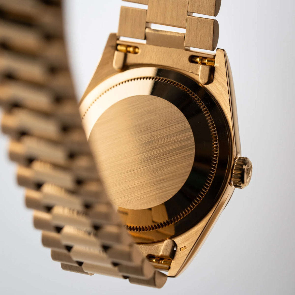 Produktfotografie der Rolex Day-Date 36 der Referenz 18238 in Gelbgold mit schwarzen Diamond-Dial am President-Armband zeigt den Gehäuseboden und die Bandanstöße von unten