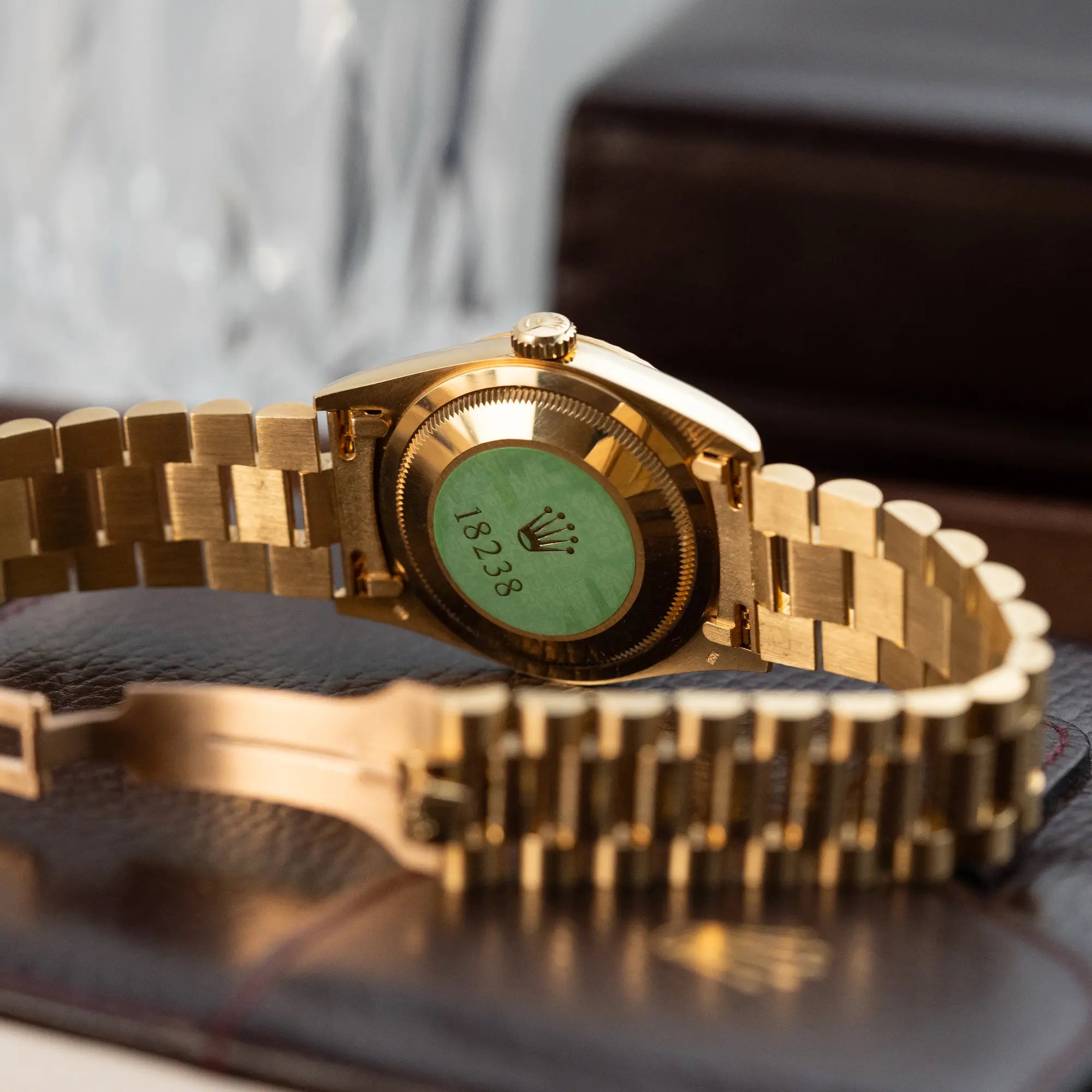 Produktfotografie der Rolex Day-Date 36 in Gelbgold (18238) mit Diamantzifferblatt der in einem neuwertigen Zustand mit Fokus auf dem grünen 18238-Sticker auf dem Gehäuseboden