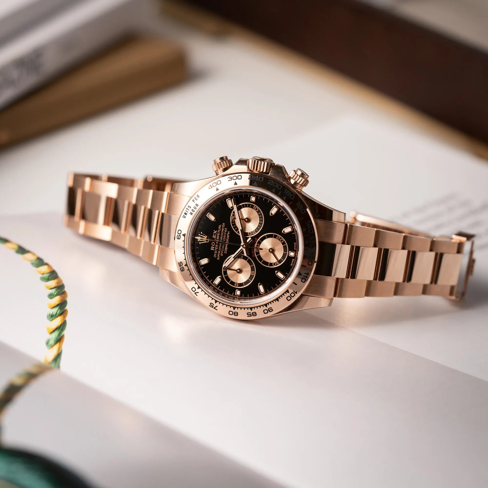Produktfotografie der Rolex Daytona Chronograph-Armbanduhr der Referenz 116505 in Everrose-Roségold mit schwarzem Zifferblatt am Oyster-Roségold-Band mit geöffneter Faltschliesse
