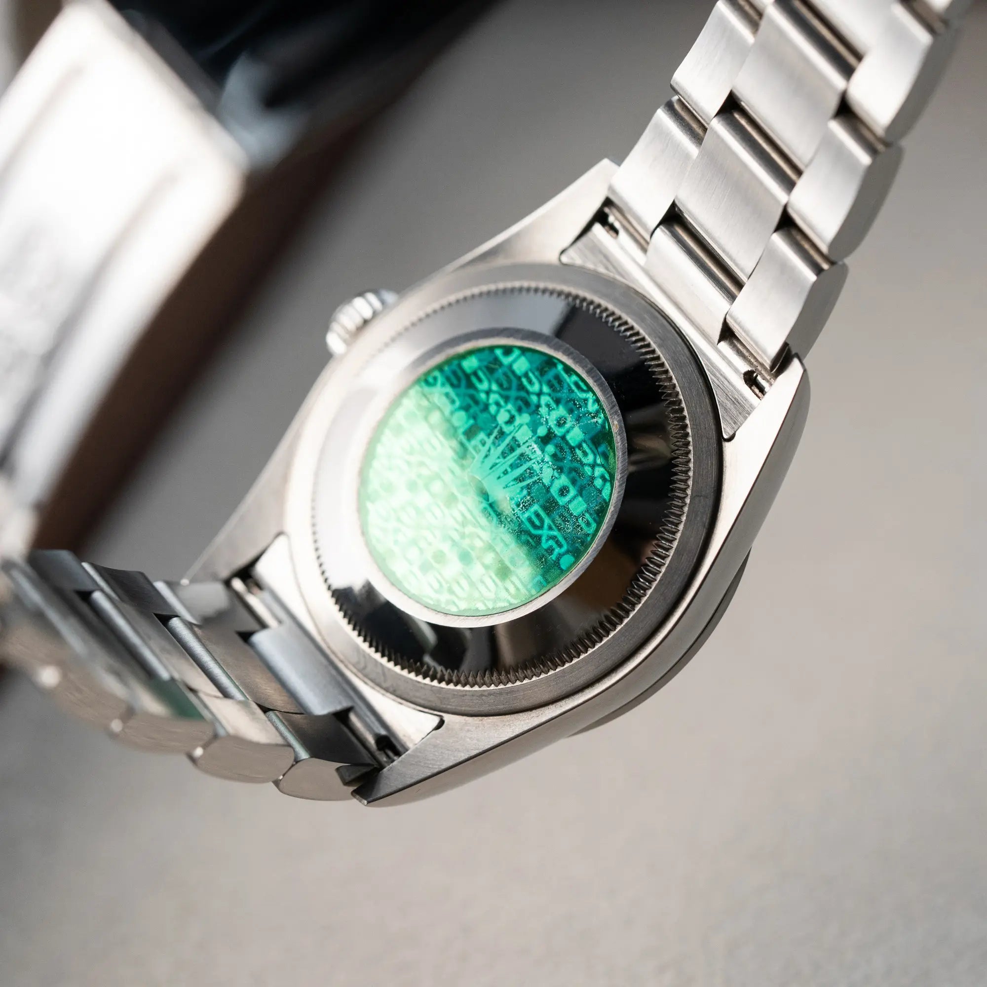 Produktfotografie der Rolex Explorer 36 in Stahl mit der Referenz 1142700 in einem nahezu neuwertigen Zustand aus 2004 mit Fokus auf dem Gehäuseboden mit grünem Rolex-Sticker