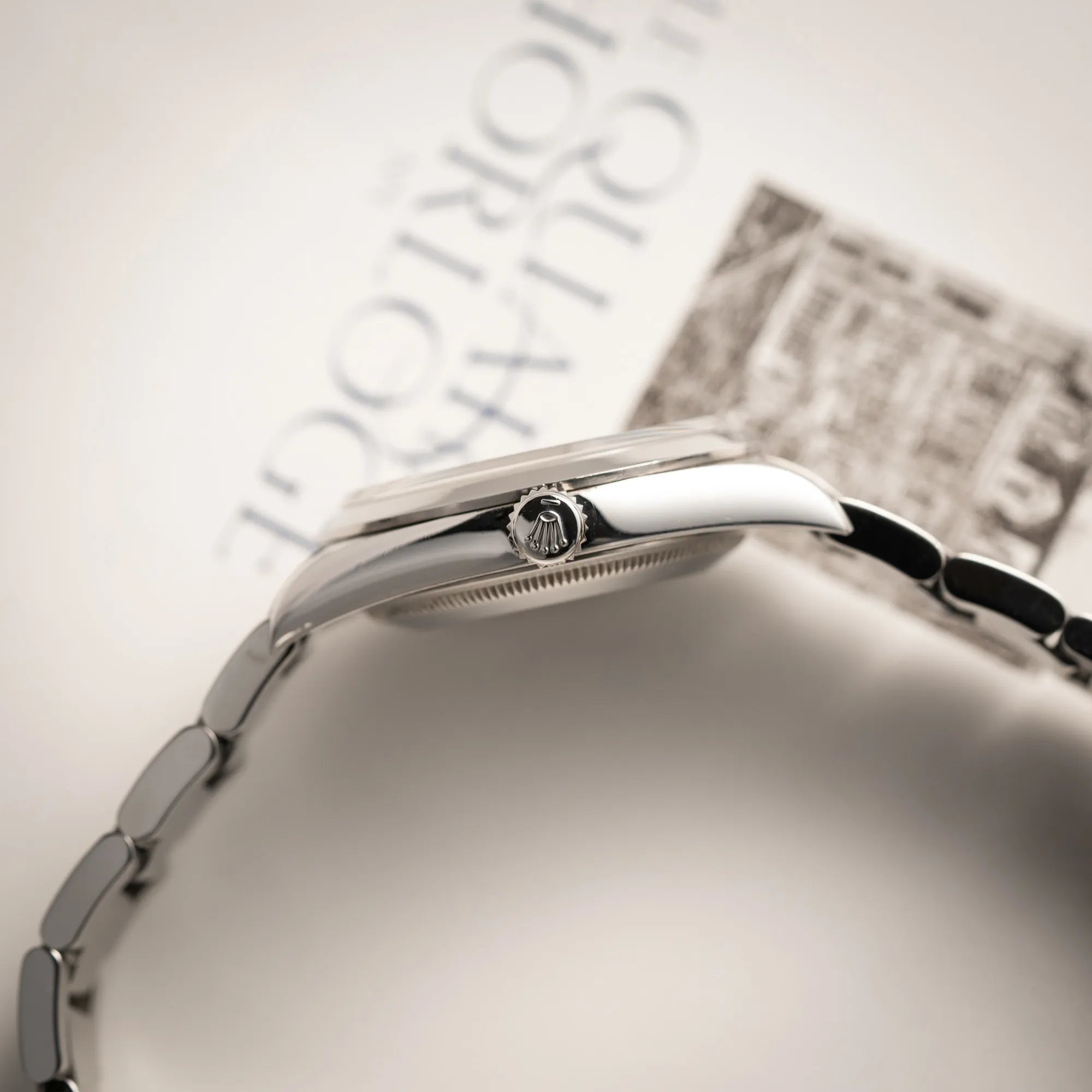 Produktfotografie der Rolex Explorer 36 der Referenz 114270 mit dem klassischen schwarzen 3-6-9 Zifferblatt zeigt die seitliche Gehäuseflanke und die Aufzugskrone