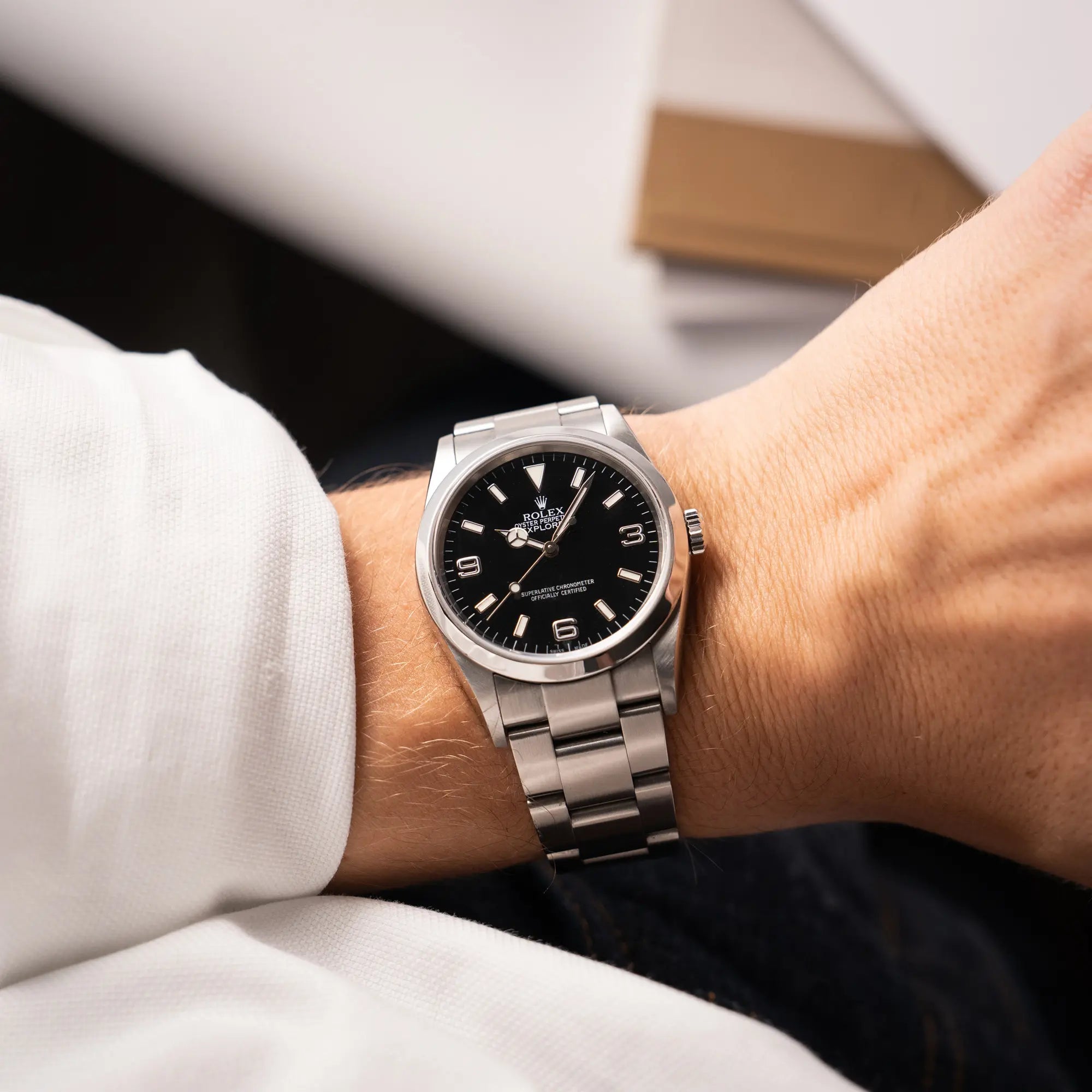 Mann präsentiert die Rolex Explorer 36 der Referenz 114270 mit dem klassischen schwarzen 3-6-9-Explorer-Zifferblatt am Oyster-Stahlband