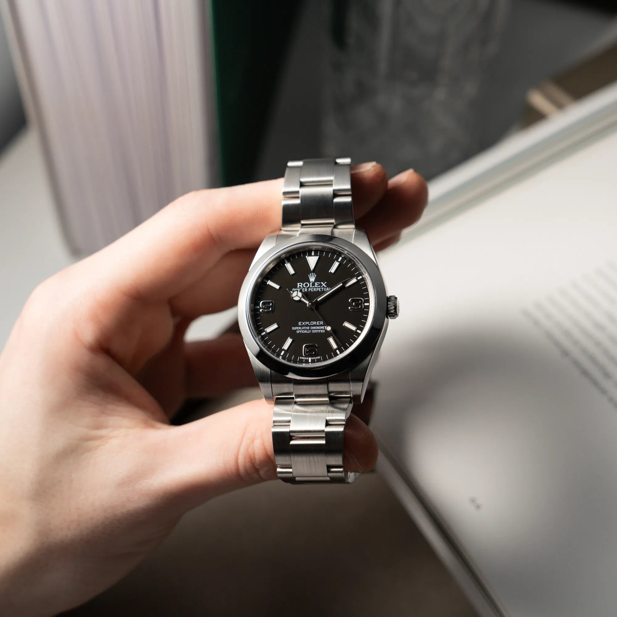 Mann präsentiert die Rolex Explorer 39 der Referenz 214270 mit dem schwarzen 3-6-9 Zifferblatt in die Kamera