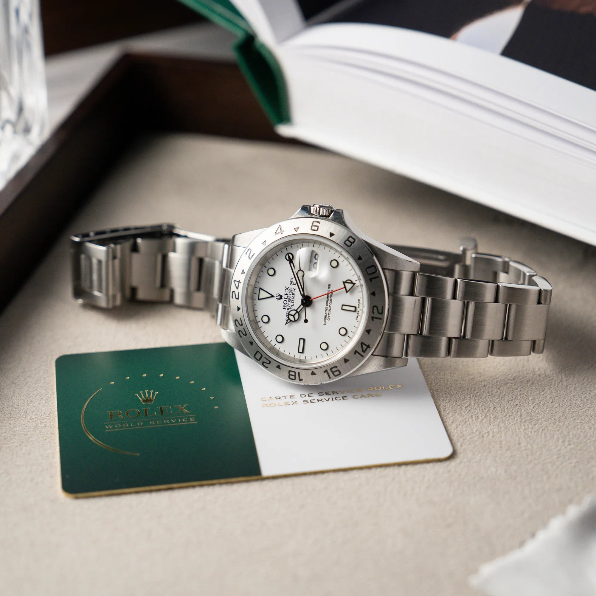 Produktfotografie der Rolex Explorer 2 - Referenz 16570T - mit dem weißen Polar-Zifferblatt mit 2024er Rolex-Service-Card