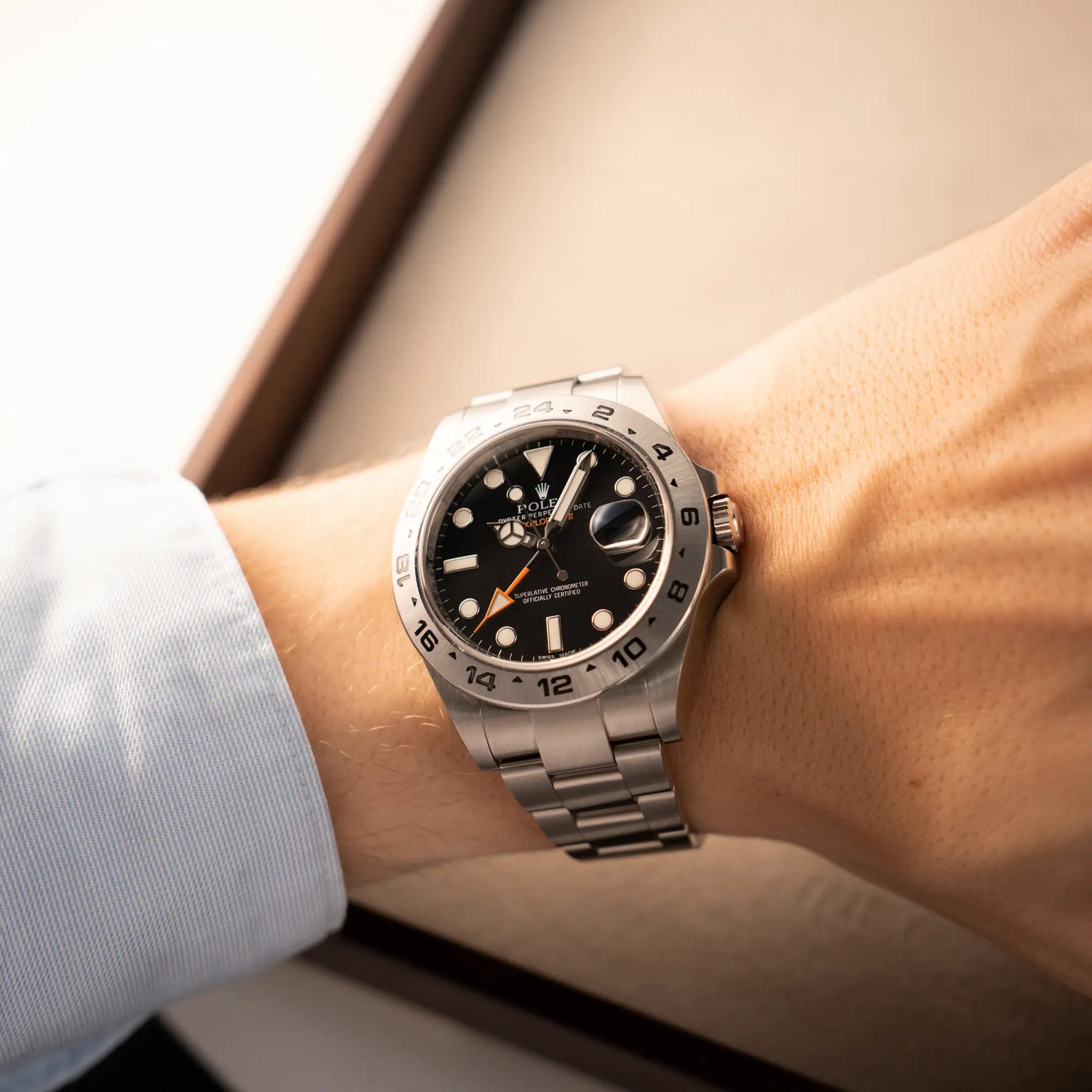 Mann trägt die Rolex Explorer 2 Orangehand im Top-Zustand der Referenz 216570 mit schwarzem Zifferblatt an seinem Handgelenk für einen Wrisstshot