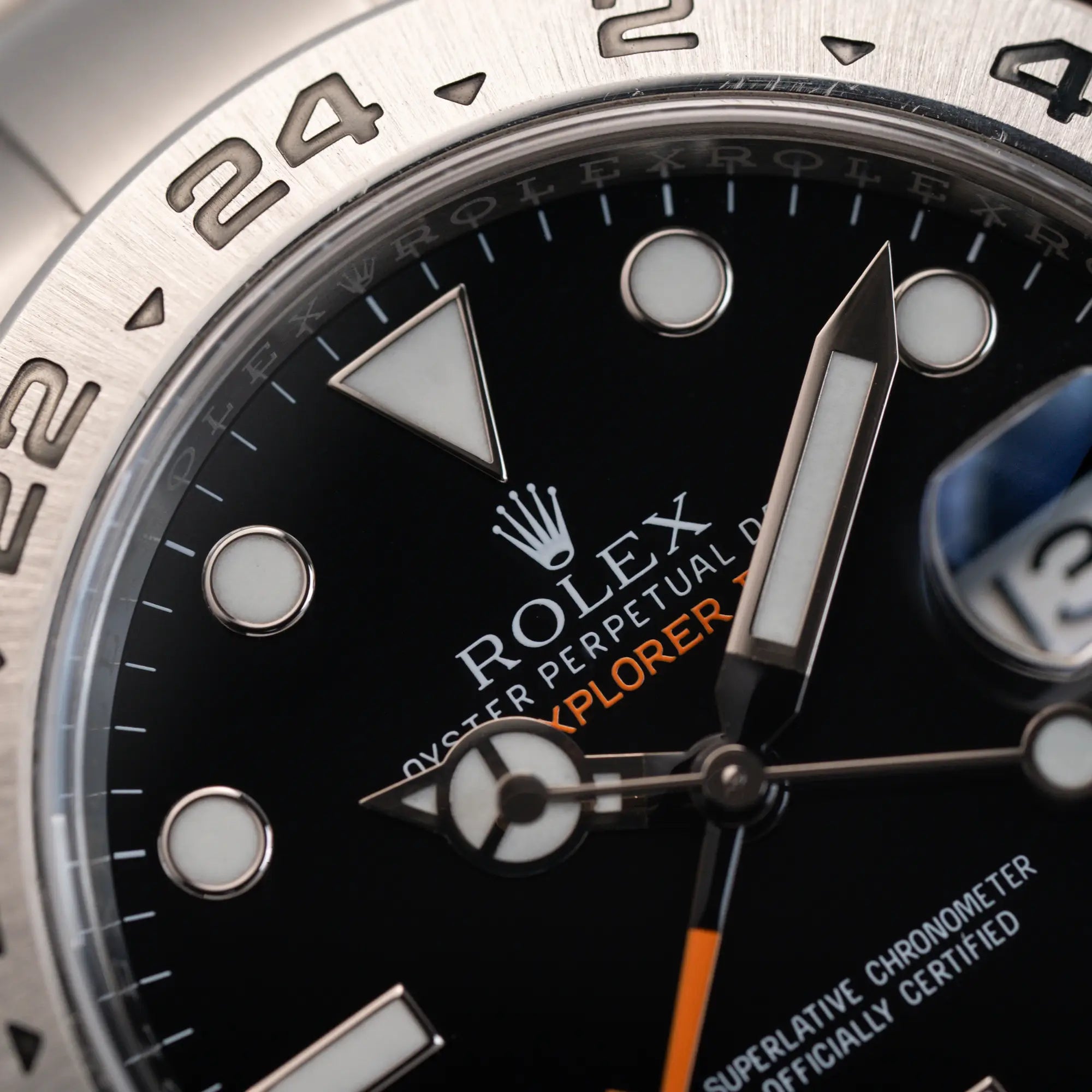Makroaufnahme des Zifferblatts und Zeigersatzes der Rolex Explorer 2 Orangehand im Top-Zustand der Referenz 216570 mit schwarzem Zifferblatt