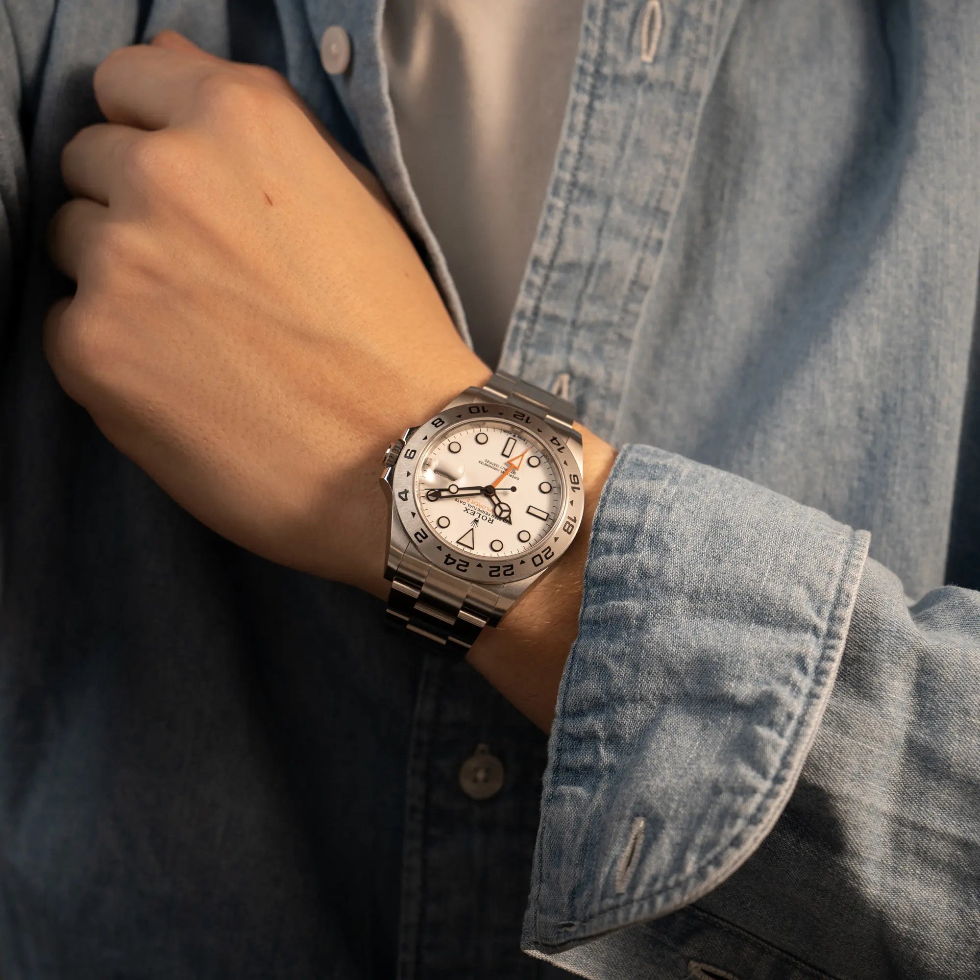 Mann trägt die Rolex Explorer 2 der Referenz 226570 mit dem Polar Zifferblatt und orangem GMT-Zeiger am Handgelenk