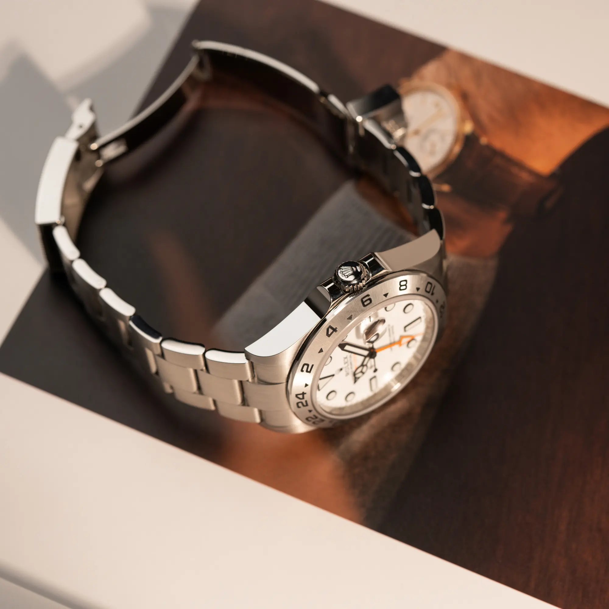 Produktfotografie der Rolex Explorer 2 der Referenz 226570 mit dem Polar Zifferblatt und orangem GMT-Zeiger mit Fokus auf der Aufzugskrone