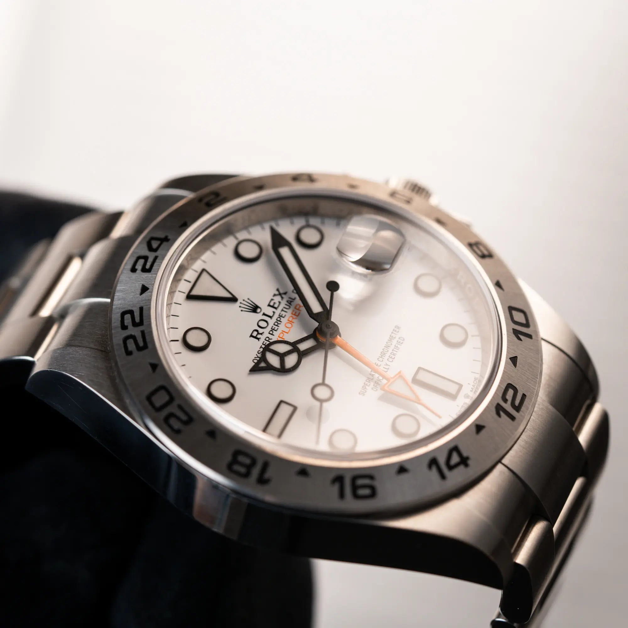 Detailaufnahme des Uhrenkopfes der Rolex Explorer 2 der Referenz 226570 mit dem Polar Zifferblatt und orangem GMT-Zeiger (seitliche Ansicht)