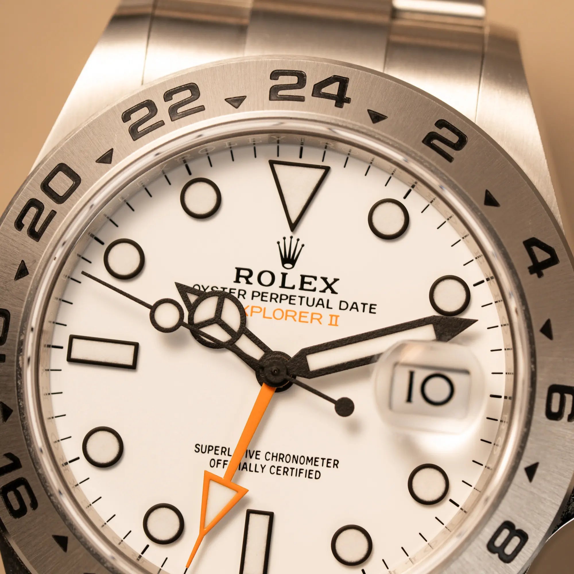 Makroaufnahme der Rolex Explorer 2 der Referenz 226570 mit dem Polar Zifferblatt und orangem GMT-Zeiger zeigt den Zustand des "Polar"-Dials und der Lünette aus Edelstahl