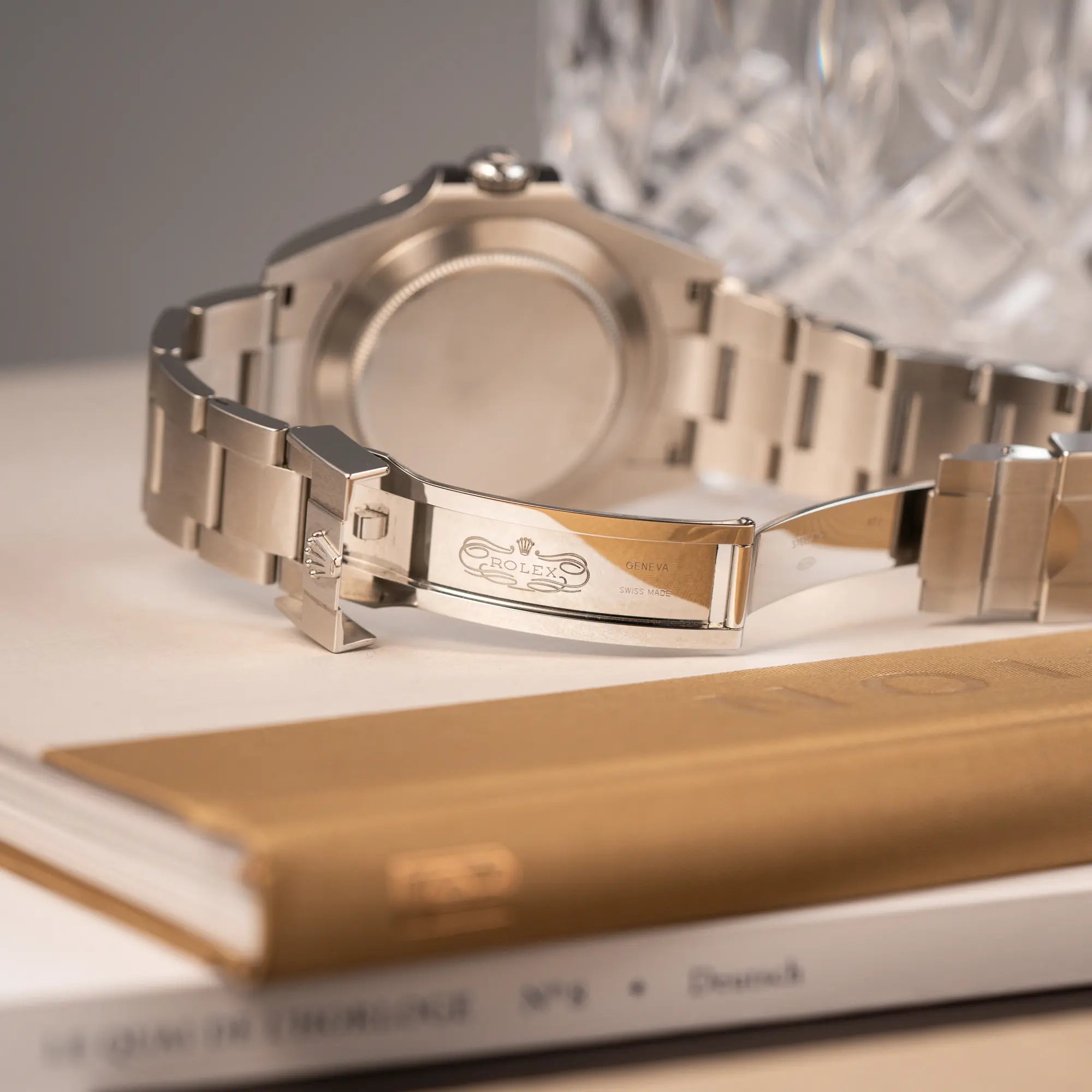 Produktfotografie der Rolex Explorer 2 der Referenz 226570 mit dem Polar Zifferblatt und orangem GMT-Zeiger zeigt das klassische Rolex Logo im Inneren der Oyster-Faltschliesse