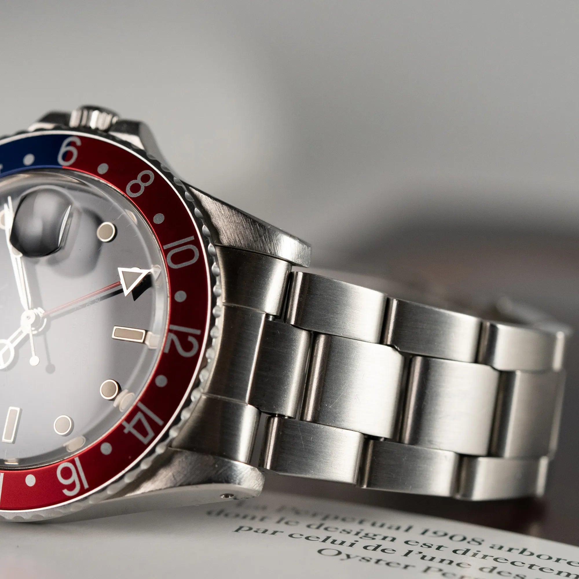 Detailaufnahme der Rolex GMT Master 1675 mit dem Nickname Pepsi mit blau-roter Lynette mit Fokus auf den Bandanstößen