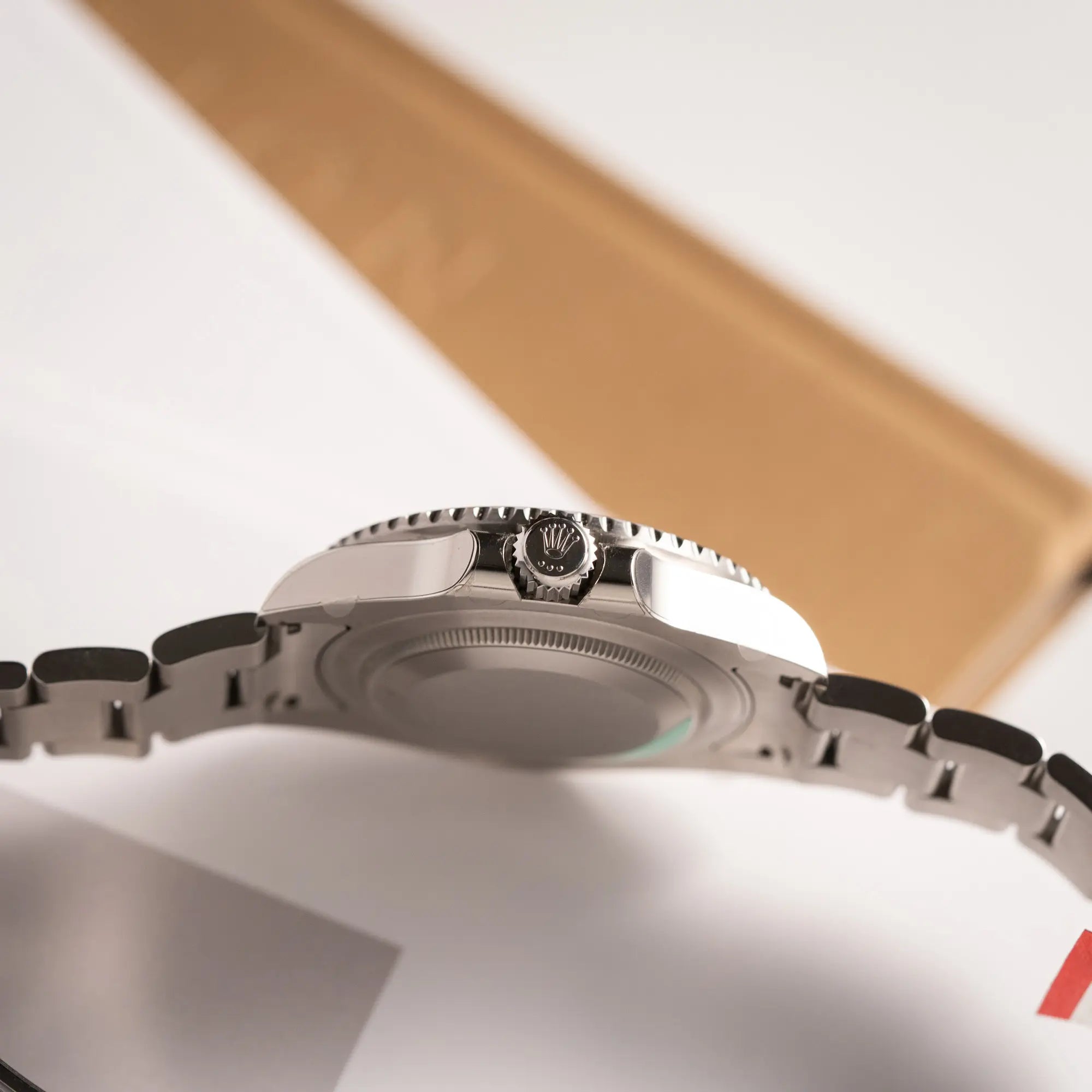 Seitliche Gehäuseflanke mit Blick auf die Aufzugskrone der Rolex GMT-Master II der Referenz 116710BLNR mit dem Nickname "Batman" mit der schwarz blauen Keramik-Lünette am Oyster-Stahlband im verklebten Neuzustand