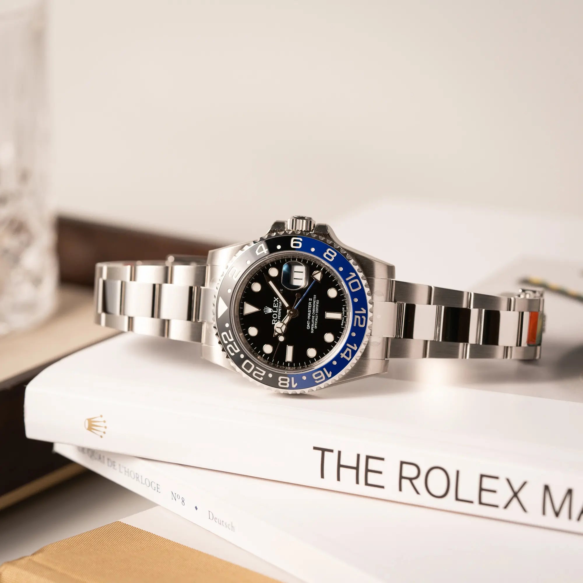 Produktfotografie der Rolex GMT-Master II der Referenz 116710BLNR mit dem Nickname "Batman" mit der schwarz blauen Keramik-Lünette am Oyster-Stahlband im verklebten Neuzustand