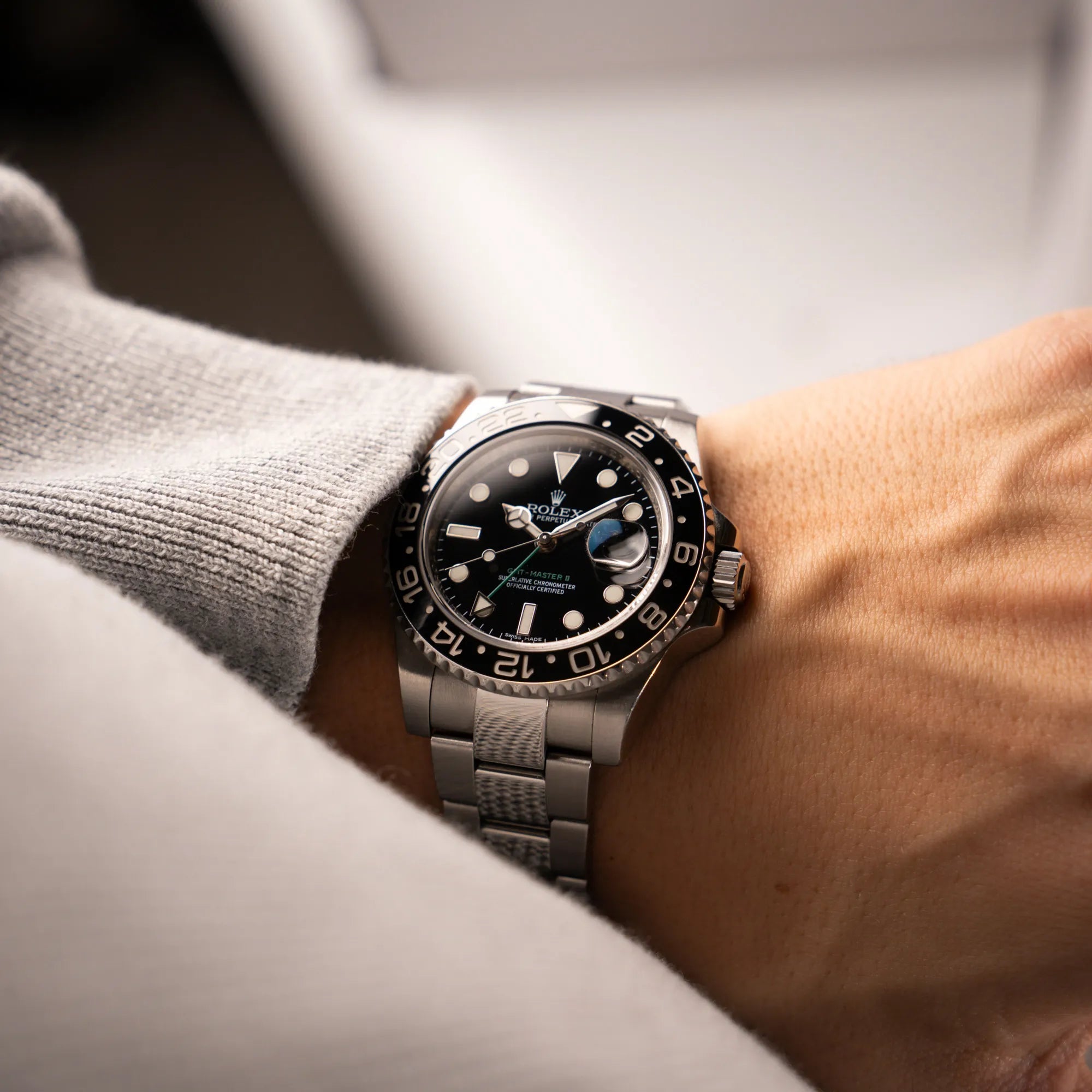 Mann trägt die Rolex GMT-Master II 116710LN mit schwarzer Keramik-Lünette und dem typischen grünem GMT-Zeiger für einen Wristshot an seinem Handgelenk