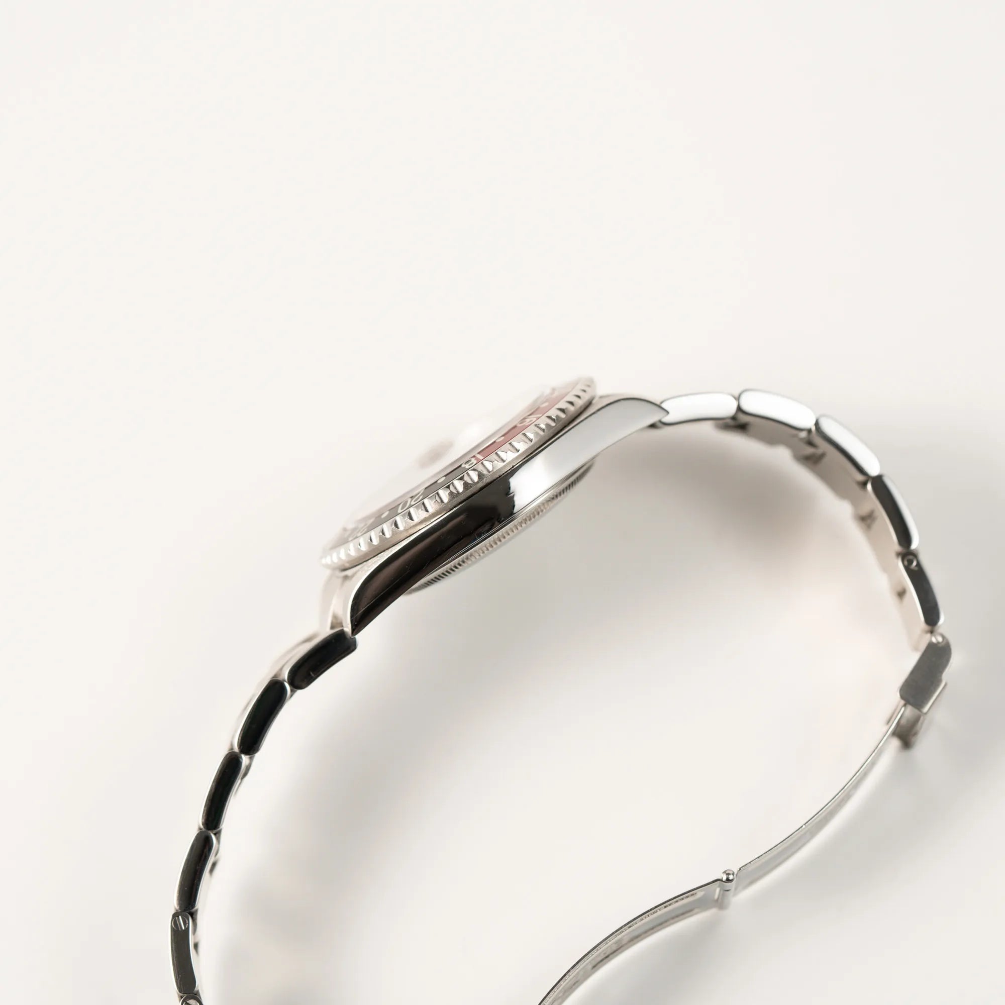 Seitliche Gehäuseflanke der Rolex GMT-Master II 16710 mit der schwarz-roten "Coke" Aluminium-Lünetten-Einlage aus 2003 am Oyster Stahlband