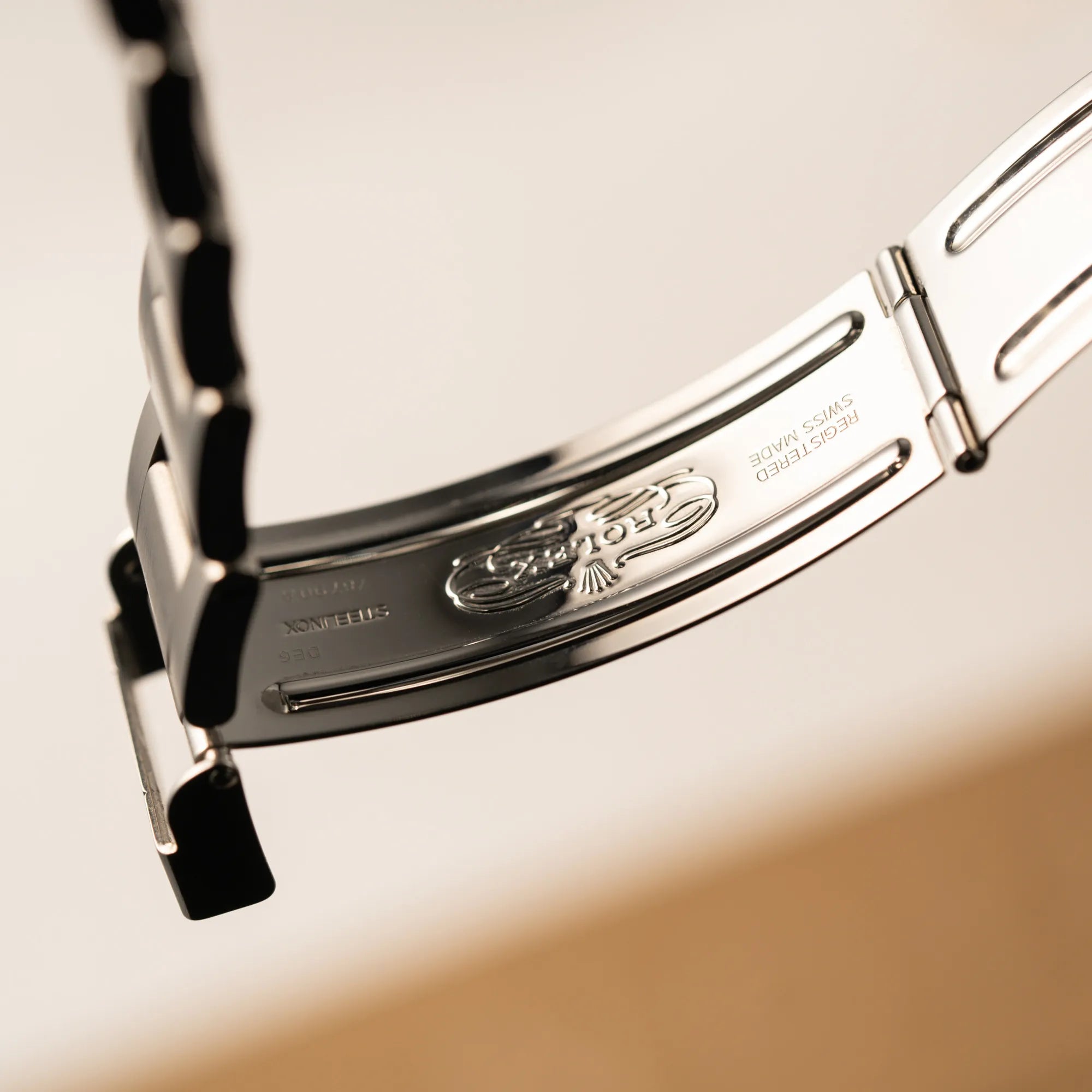 Detailaufnahme des klassischen Rolex-Logos im Inneren der Oyster-Stahl-Faltschliesse der Rolex GMT-Master II 16710 aus 2001 mit schwarzem Aluminium-Lünetten-Inlay in einem neuwertigen Zustand