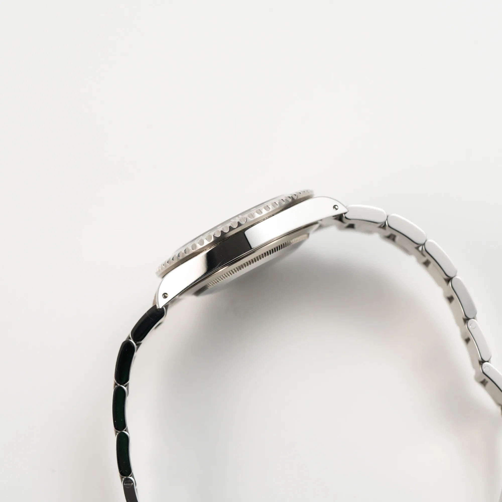 Seitliche Gehäuseflanke der Rolex GMT-Master II 16710 aus 2001 mit schwarzem Aluminium-Lünetten-Inlay in einem neuwertigen Zustand