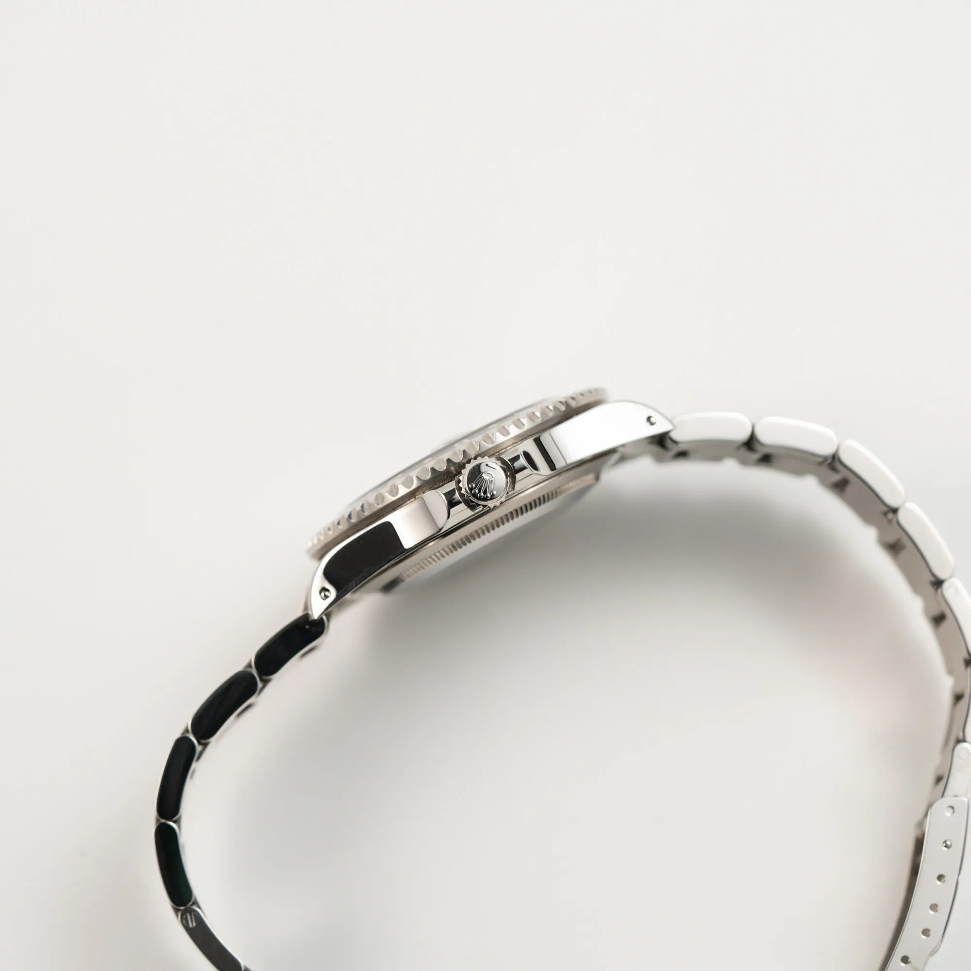 Seitliche Gehäuseflanke mit Blick auf die Aufzugskrone der Rolex GMT-Master II 16710 aus 2001 mit schwarzem Aluminium-Lünetten-Inlay in einem neuwertigen Zustand