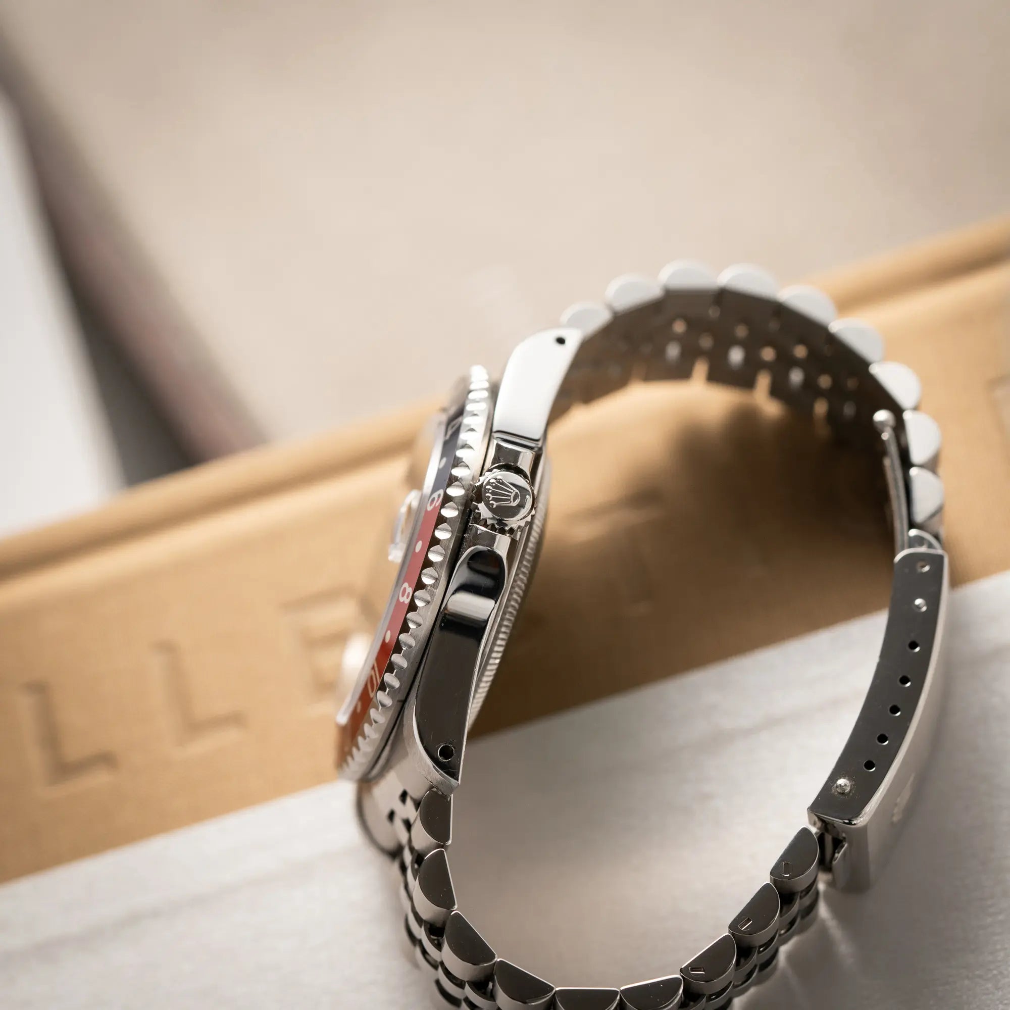 Produktfotografie der Rolex GMT-Master II 16710 mit der blau-roten Pepsi-Lünette am Jubilee-Armband zeigt die seitliche Gehäuseflanke mit Blick auf die Aufzugskrone