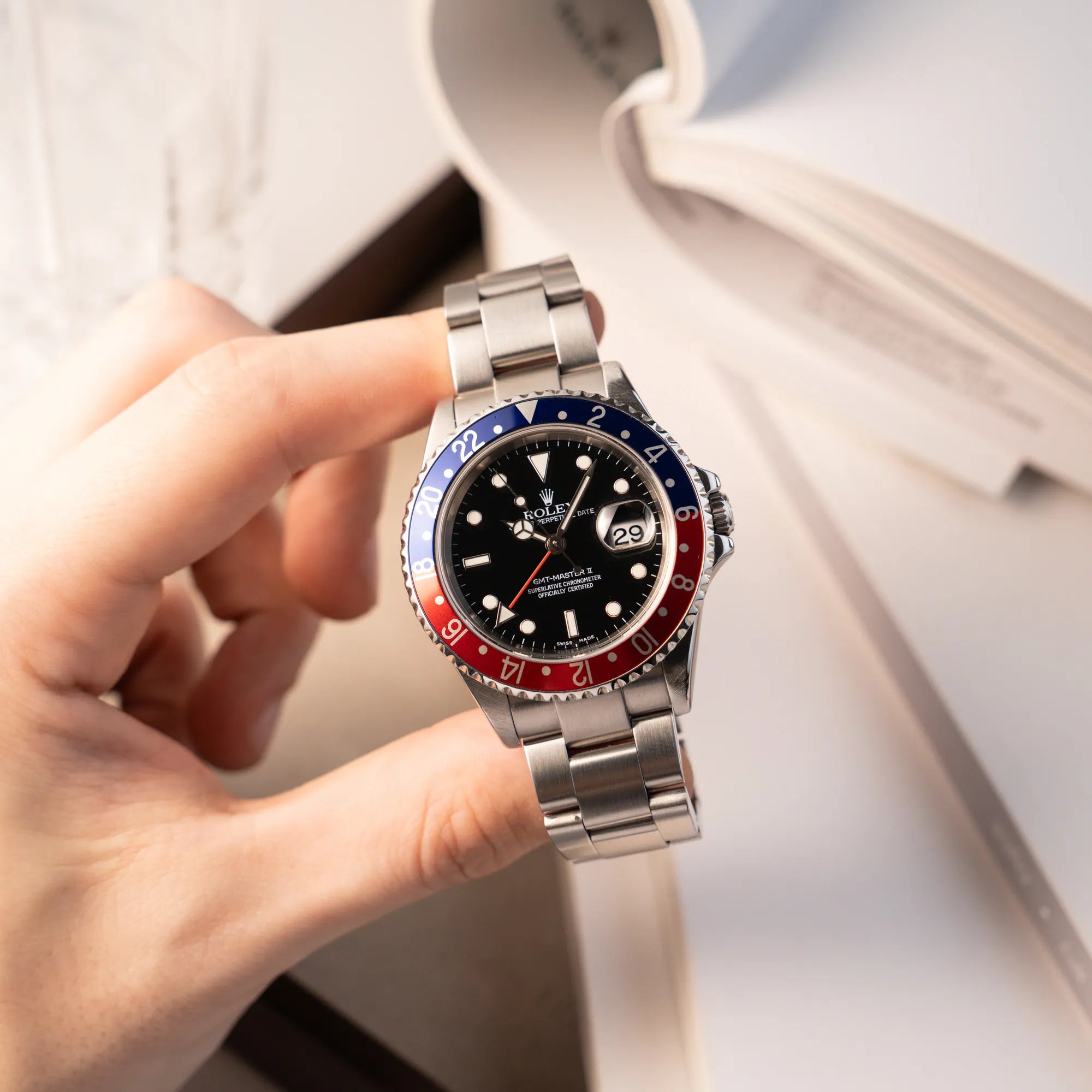 Mann hält die Rolex GMT-Master II 16710 aus 2007 mit blau-roter Pepsi-Lünette mit kräftigen Farbtönen und zeigt die Uhr in die Kamera