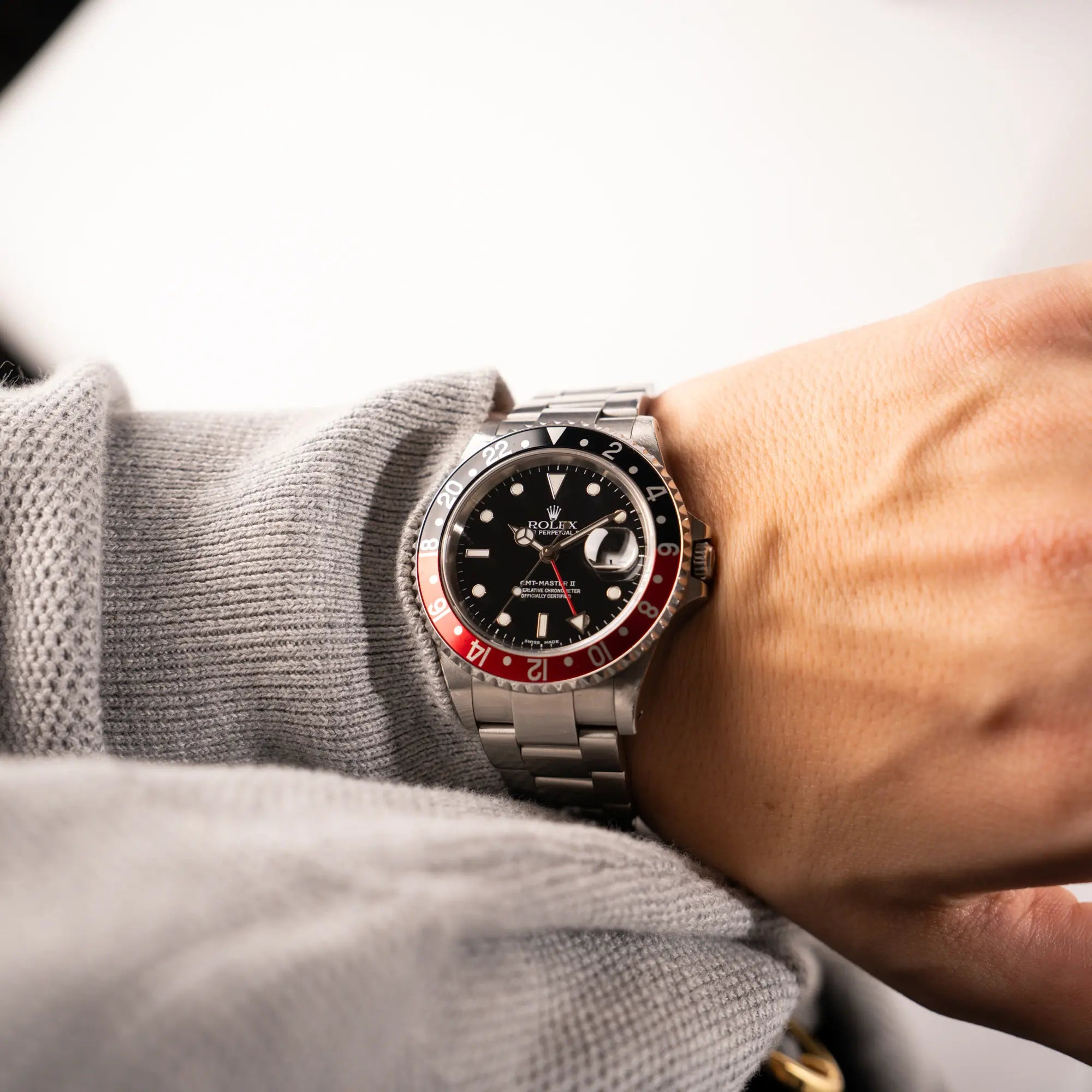 Mann trägt die Rolex GMT-Master II 16710 in Edelstahl mit schwarz-roten "Coke" Lünetten-Inlay an seinem Handgelenk